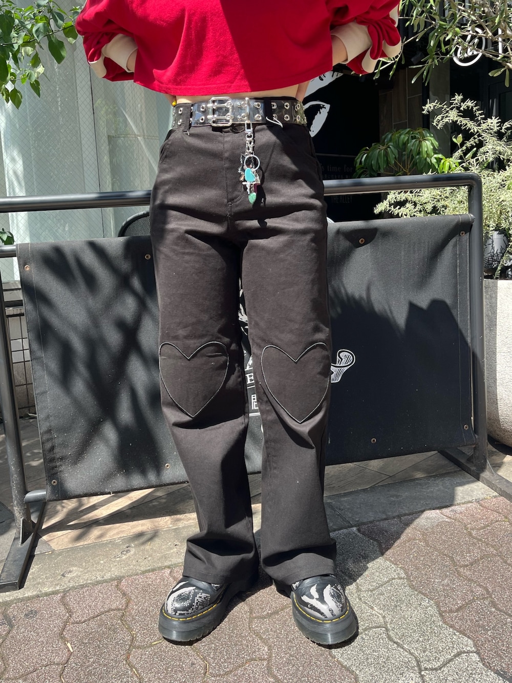 ブラック系のその他パンツ、レッド系のTシャツ/カットソー、シルバー系のネックレスを着用したレディースの秋コーディネートの7枚目の写真