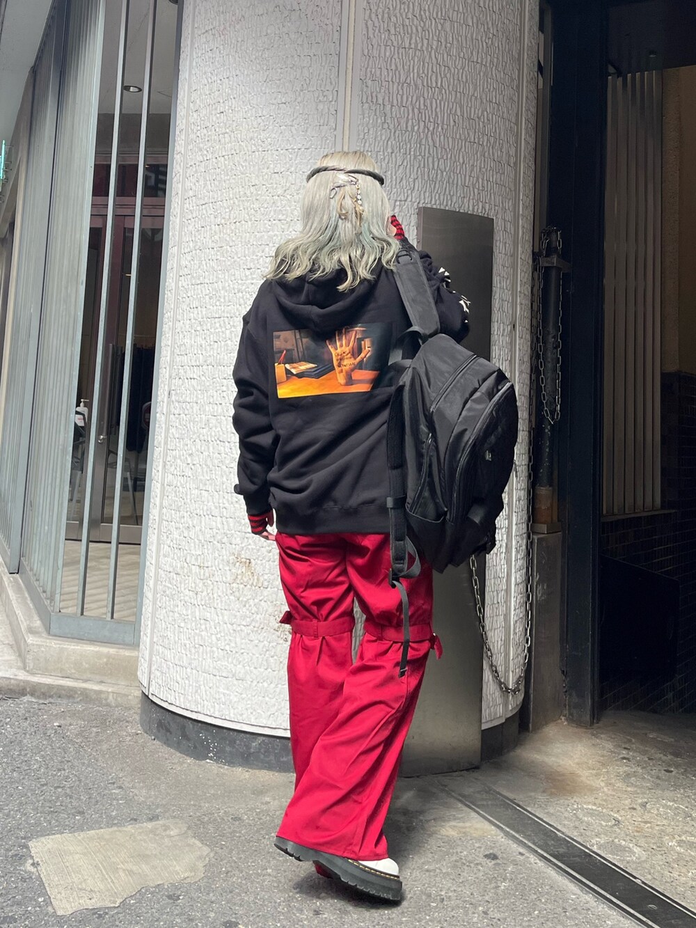 ブラック系のバックパック/リュック、ブラック系のパーカー、レッド系のその他パンツを着用したレディースの秋コーディネートの3枚目の写真