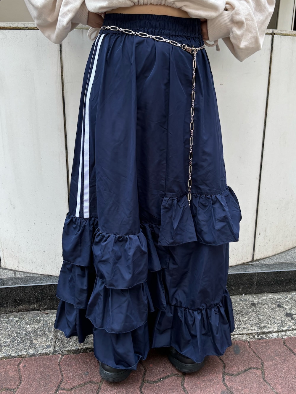 ブルー系のスカート、ホワイト系のスウェット、シルバー系のベルトを着用したレディースの夏コーディネートの7枚目の写真