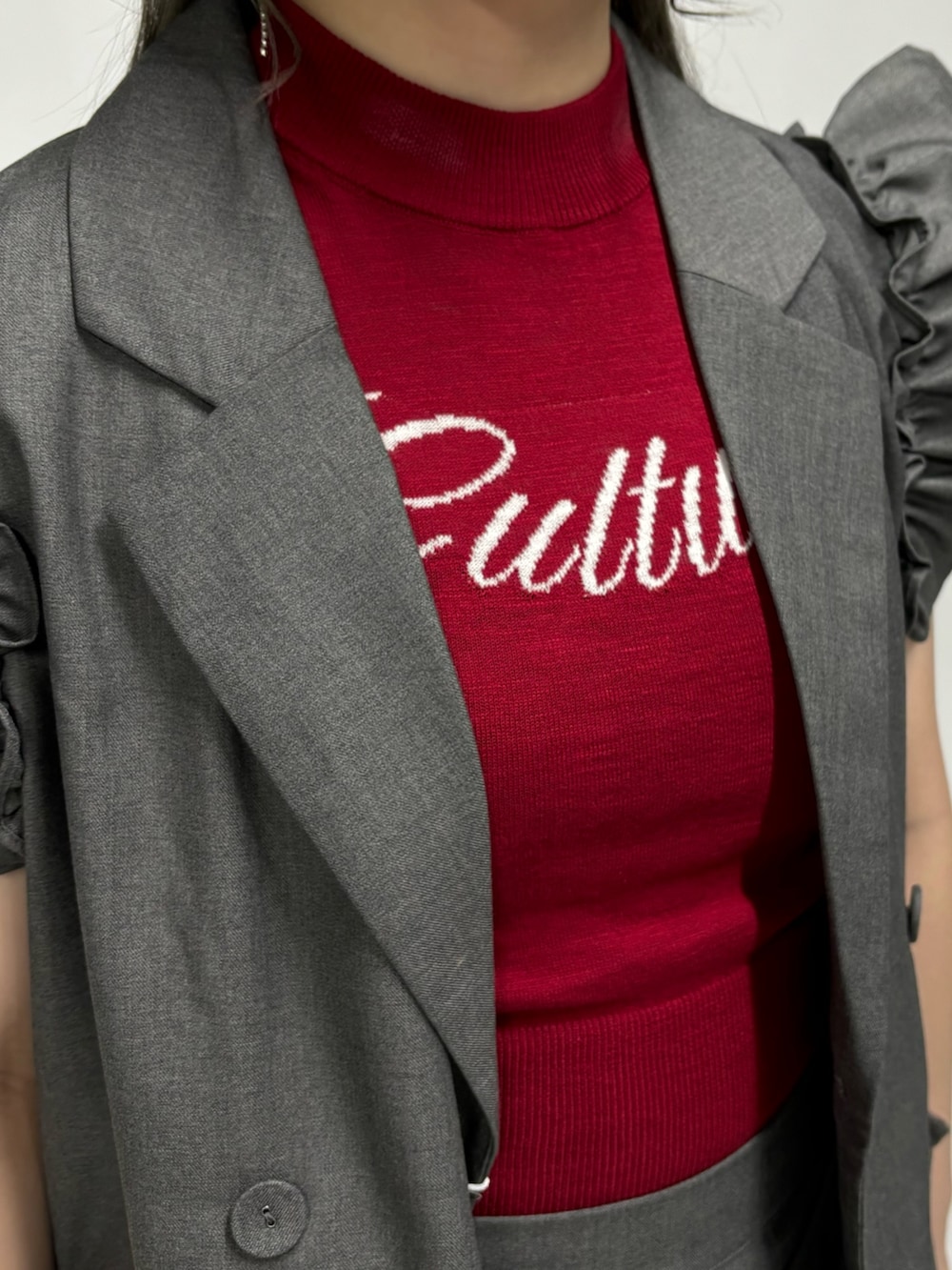 レッド系のニット/セーター、グレー系のワンピース、グレー系のその他パンツを着用したレディースの春コーディネートの6枚目の写真