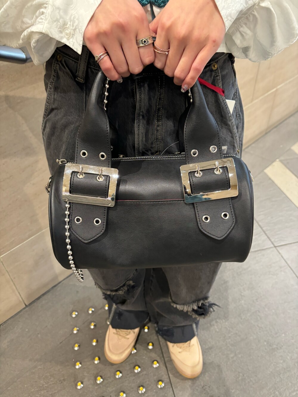 ブラック系のデニムパンツ、ブラック系のボストンバッグ、ホワイト系のシャツ/ブラウスを着用したレディースの春コーディネートの7枚目の写真