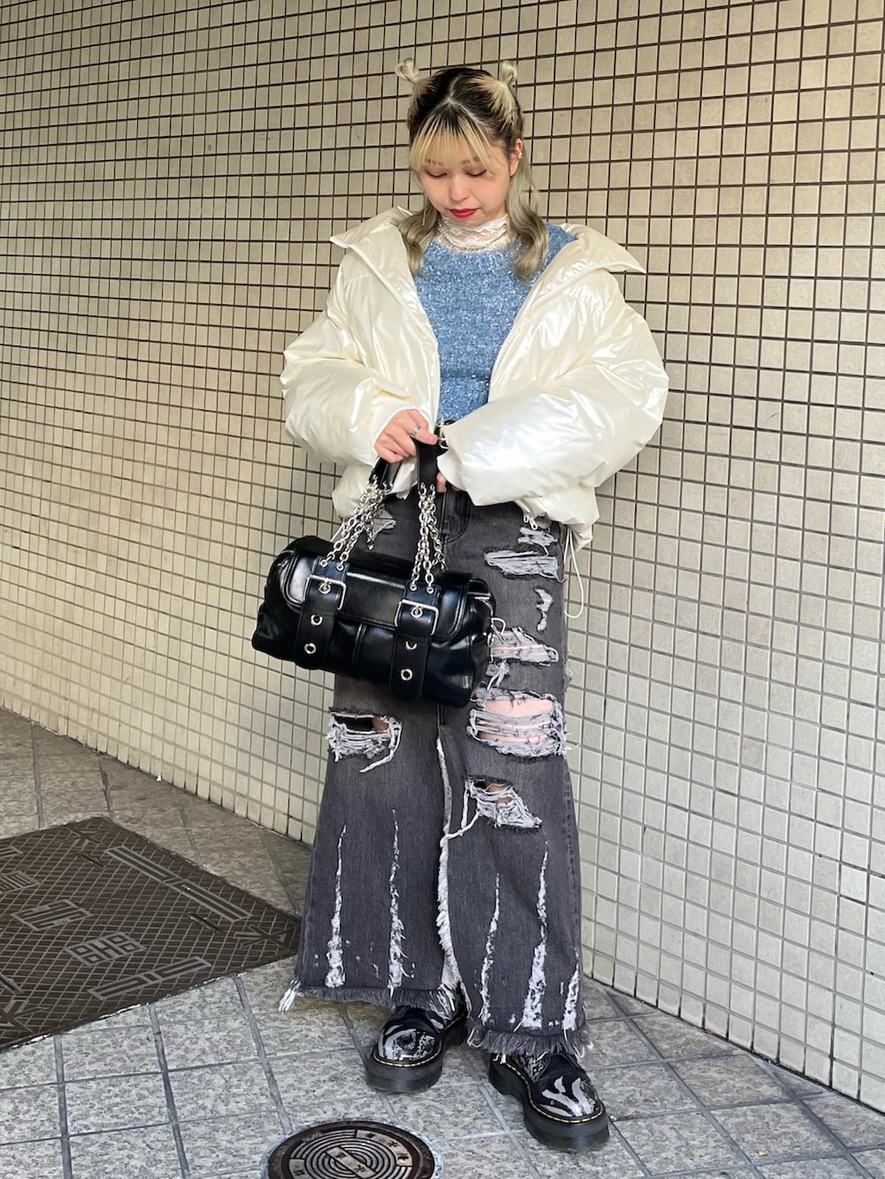 ホワイト系のTシャツ/カットソー、ブラック系のハンドバッグ、ブルー系のニット/セーターを着用したレディースの冬コーディネートの5枚目の写真