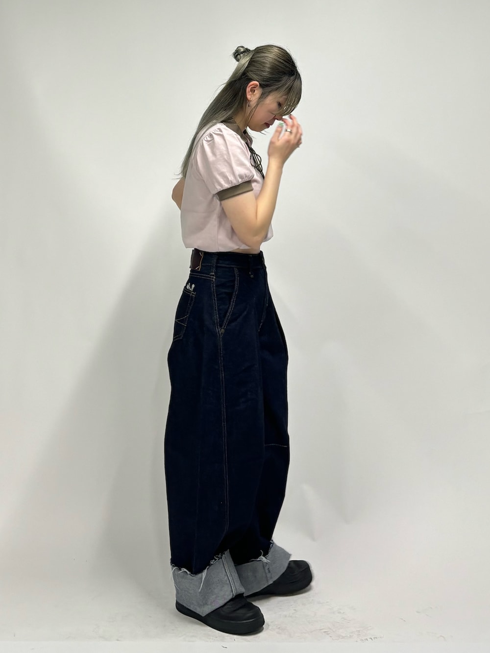 ブルー系のデニムパンツ、ピンク系のポロシャツを着用したレディースの春コーディネートの2枚目の写真