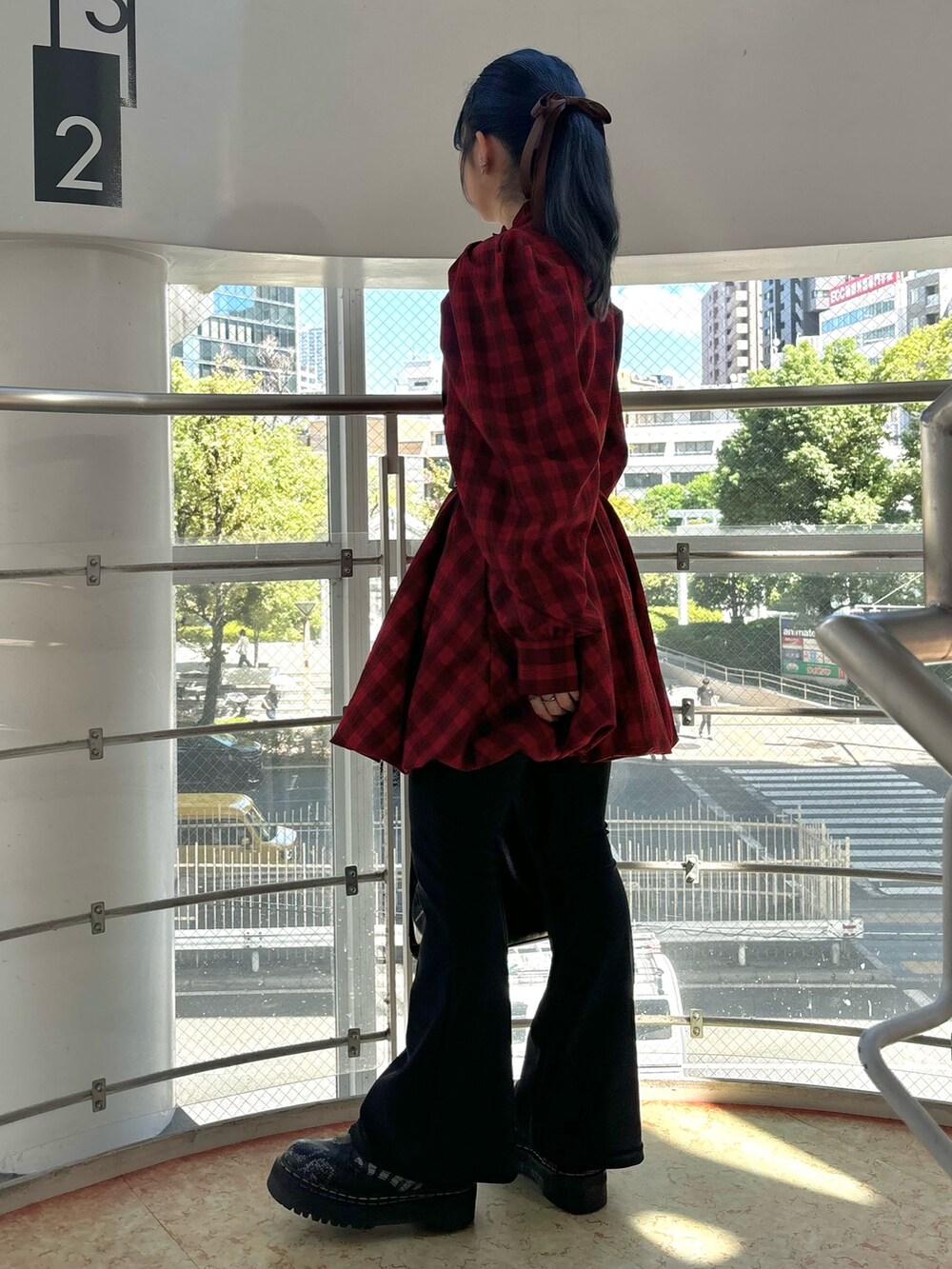 レッド系のワンピース、ブラック系のハンドバッグ、ブラック系のその他パンツを着用したレディースの秋コーディネートの2枚目の写真