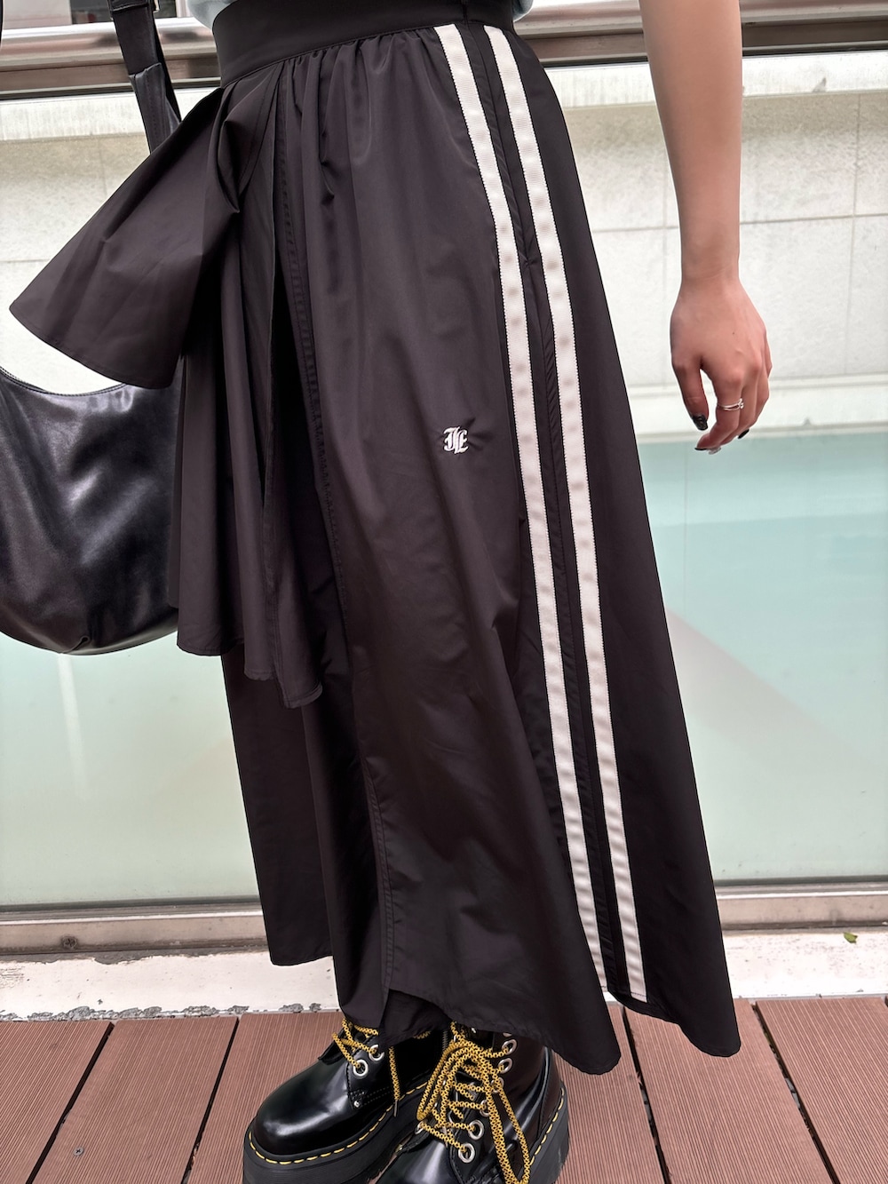 ブラック系のスカート、ブラック系のその他シューズ、ブラック系のショルダーバッグを着用したレディースの春コーディネートの7枚目の写真