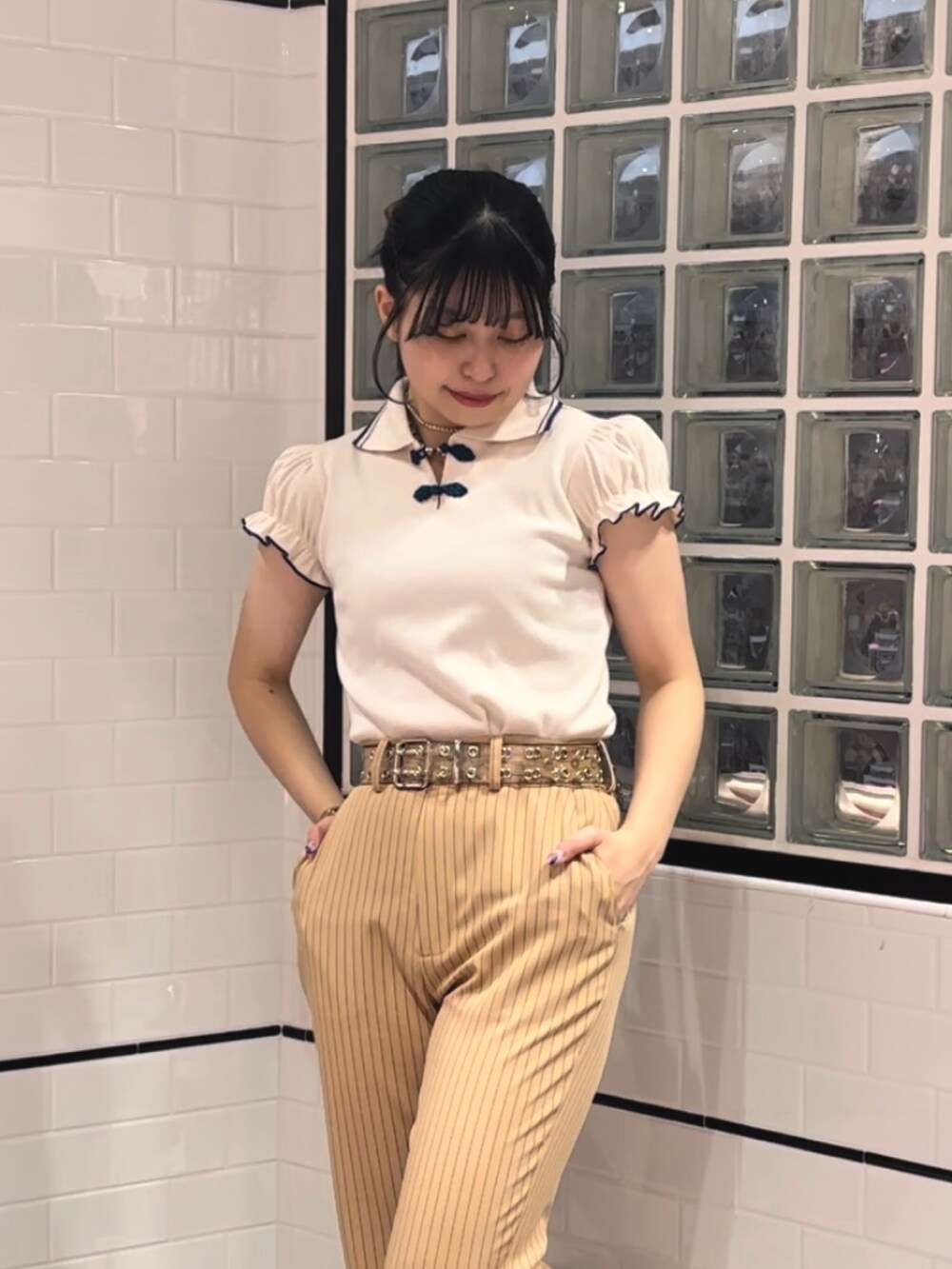 ベージュ系のその他パンツ、ブラック系のその他シューズ、ホワイト系のポロシャツを着用したレディースの冬コーディネートの4枚目の写真