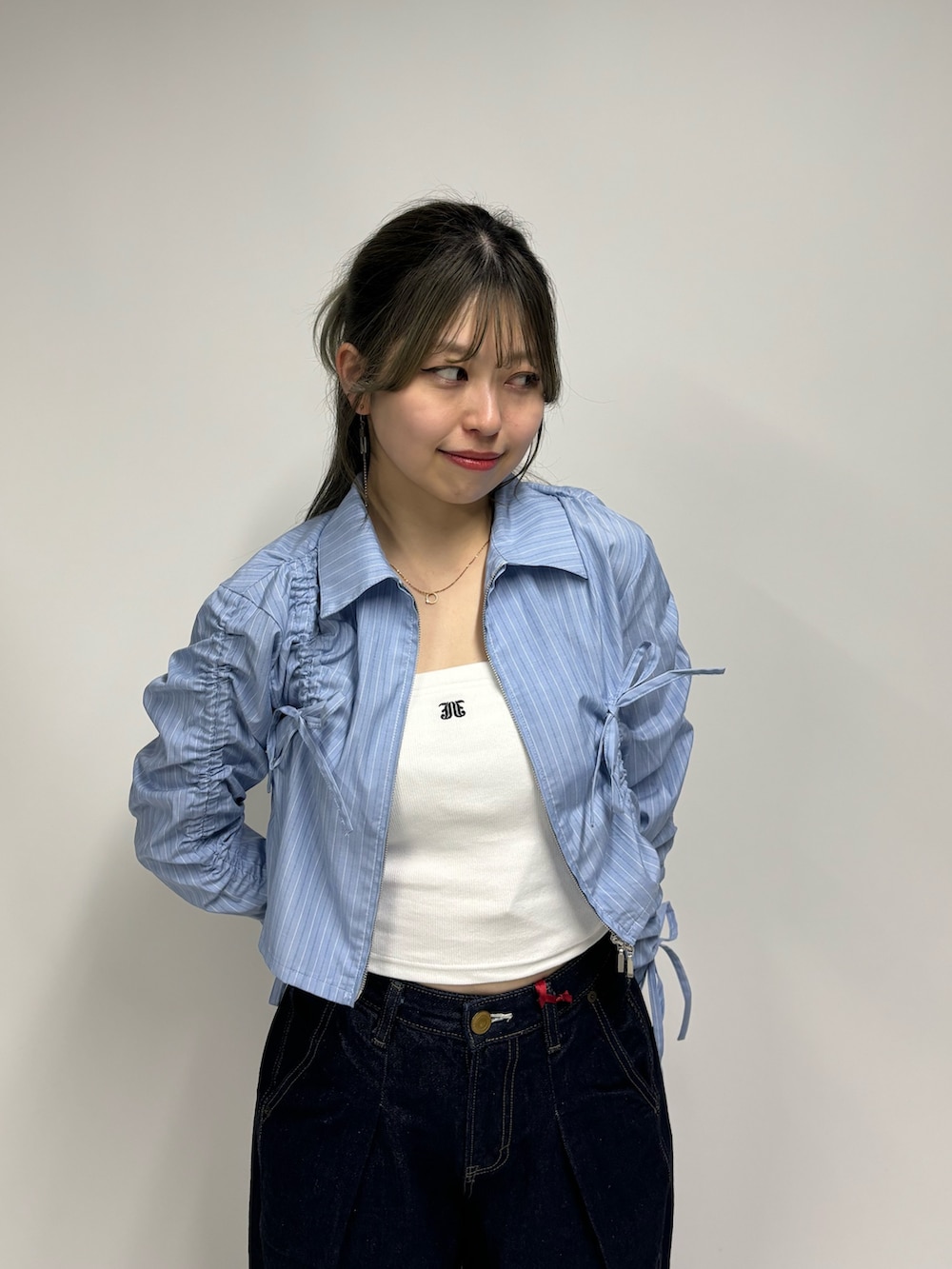 ブルー系のデニムパンツ、ホワイト系のキャミソール、ブルー系のシャツ/ブラウスを着用したレディースの春コーディネートの5枚目の写真