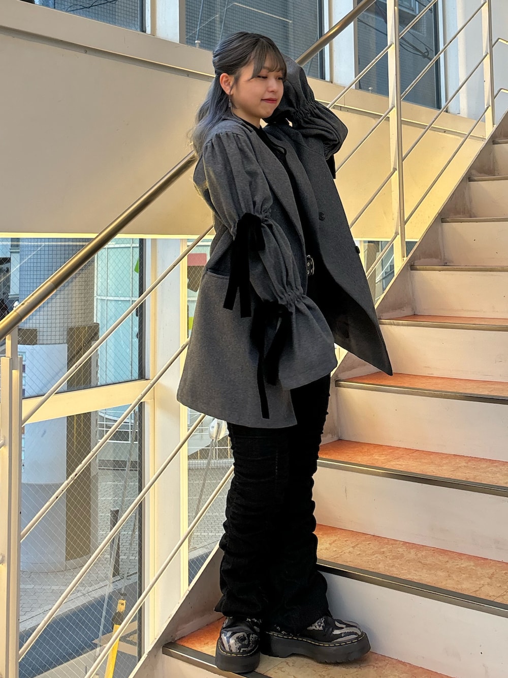 ブラック系のデニムパンツ、グレー系のその他アウター、ブラック系のTシャツ/カットソーを着用したレディースの秋コーディネートの2枚目の写真