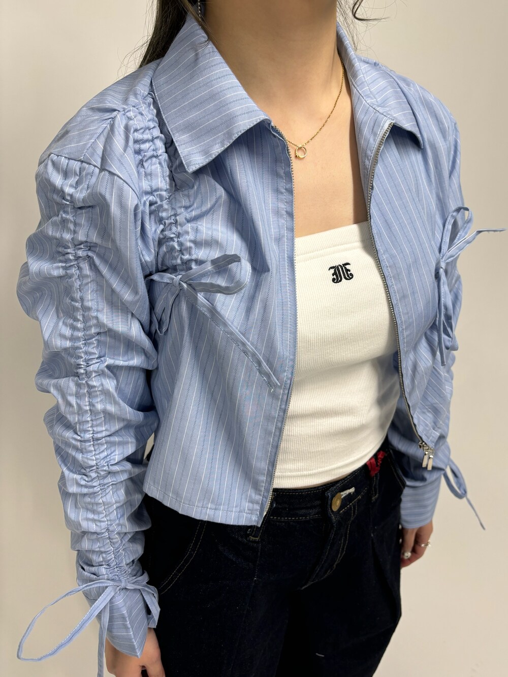 ブルー系のデニムパンツ、ホワイト系のキャミソール、ブルー系のシャツ/ブラウスを着用したレディースの春コーディネートの6枚目の写真