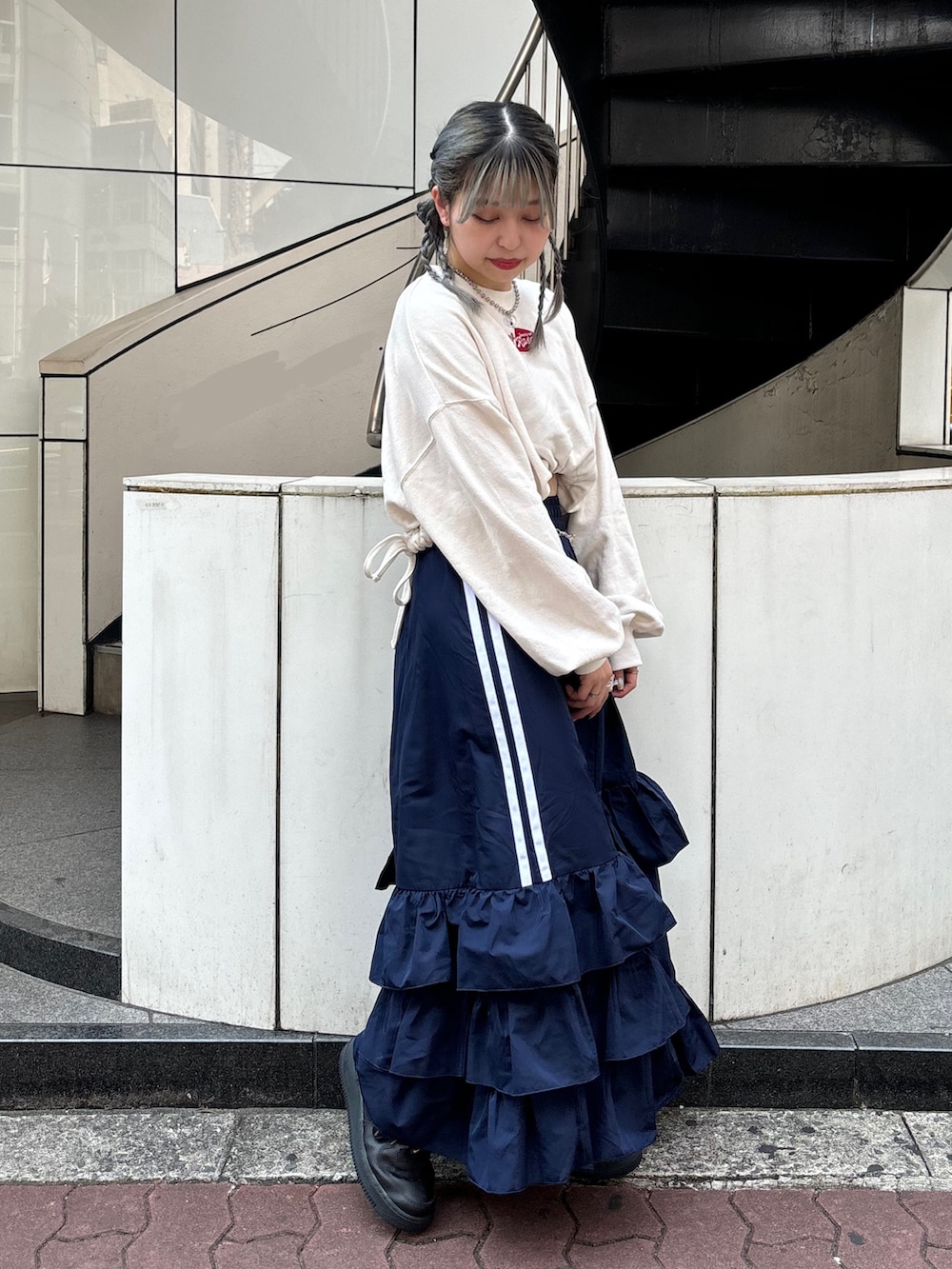 ブルー系のスカート、ホワイト系のスウェット、シルバー系のベルトを着用したレディースの夏コーディネートの2枚目の写真