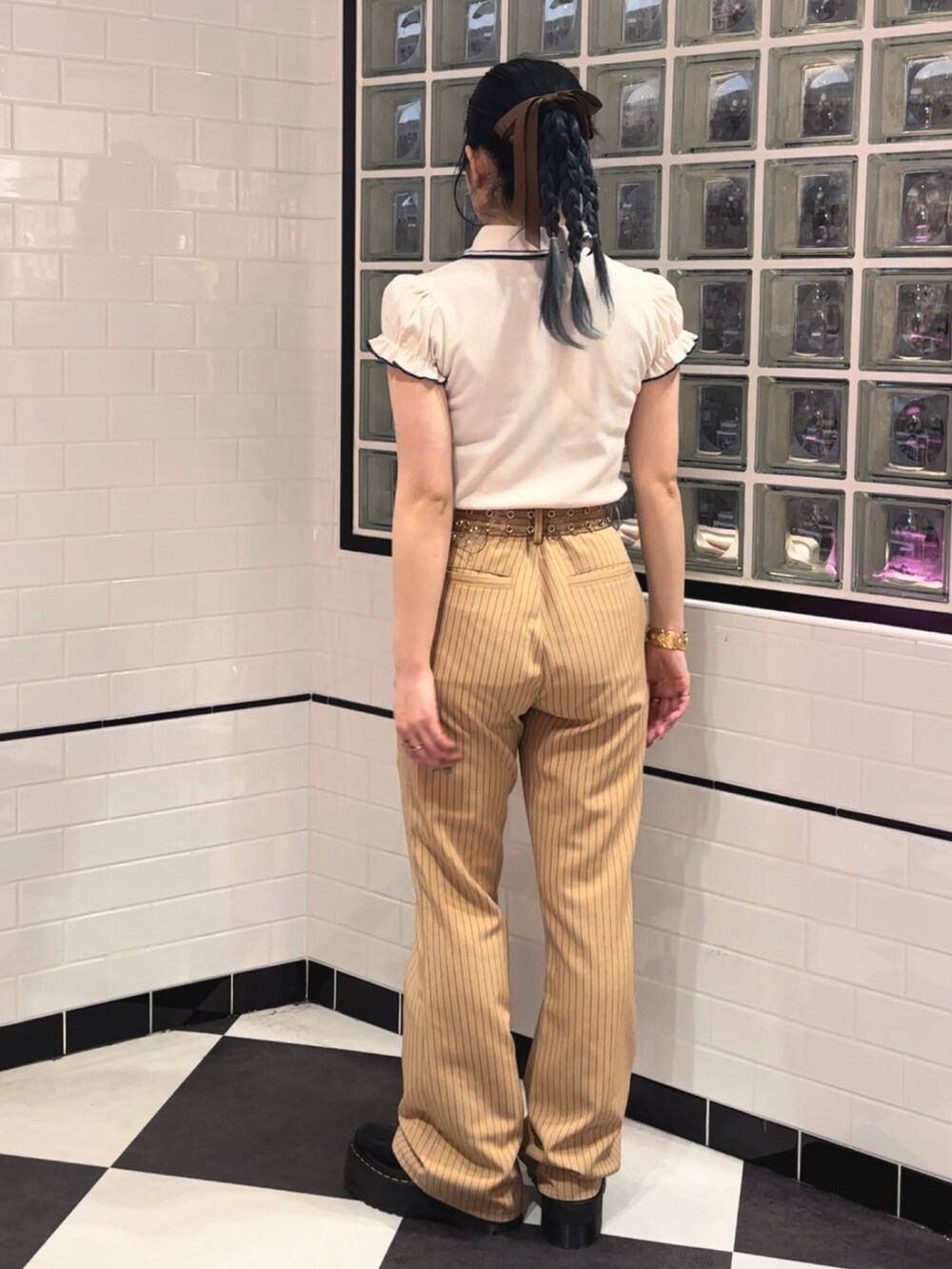 ベージュ系のその他パンツ、ブラック系のその他シューズ、ホワイト系のポロシャツを着用したレディースの冬コーディネートの3枚目の写真