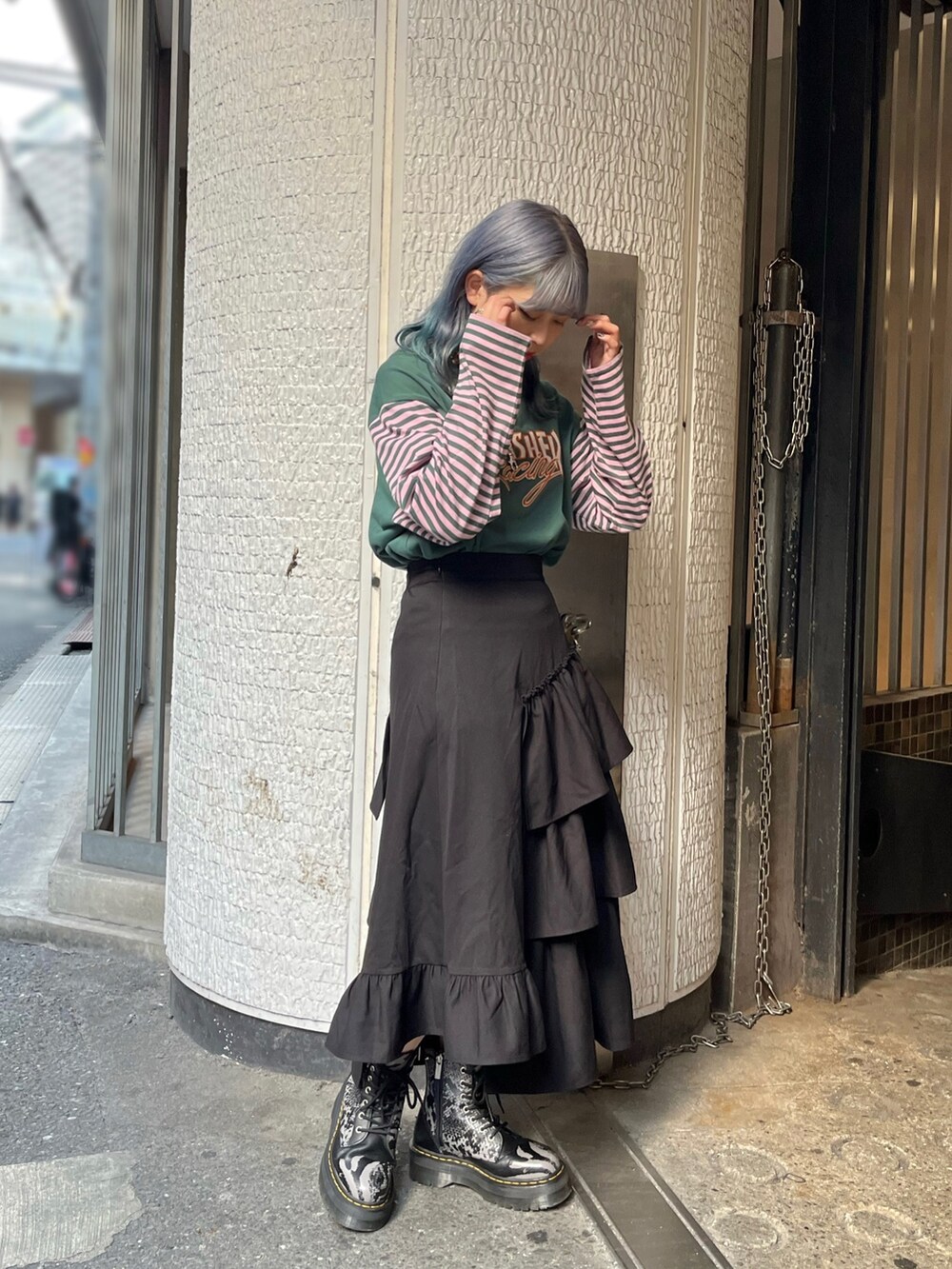 グリーン系のTシャツ/カットソー、ブラック系のスカート、シルバー系のネックレスを着用したレディースの秋コーディネートの3枚目の写真