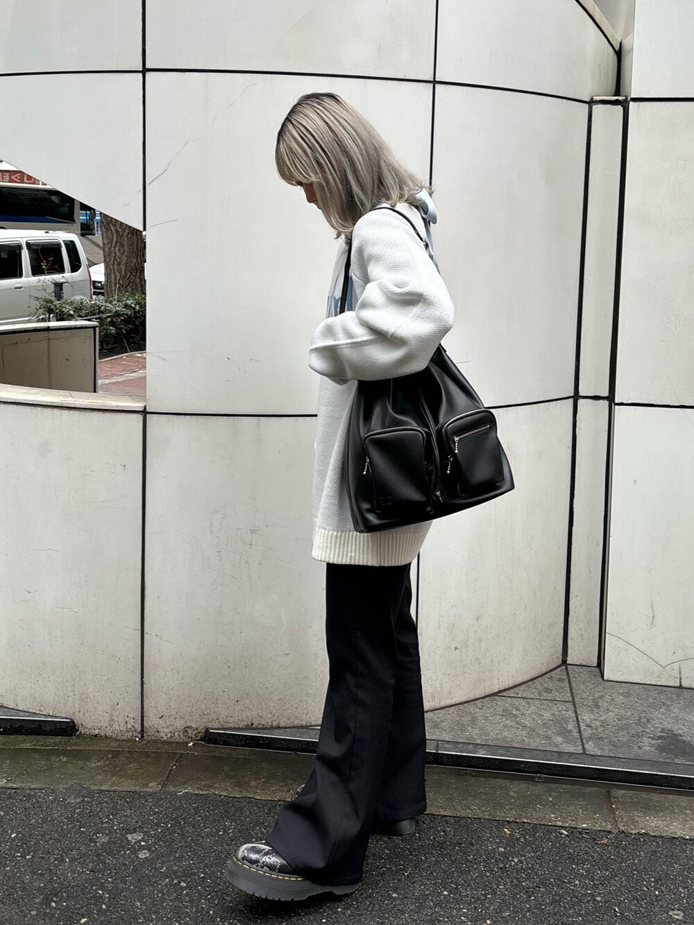 ホワイト系のニット/セーター、ブルー系のシャツ/ブラウス、ブラック系のバックパック/リュックを着用したレディースの春コーディネートの4枚目の写真