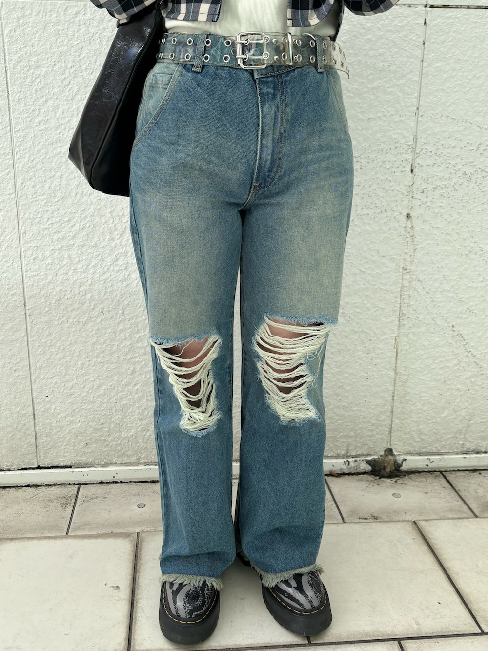 ブルー系のデニムパンツ、ブラック系のショルダーバッグ、ホワイト系のTシャツ/カットソーを着用したレディースの冬コーディネートの9枚目の写真