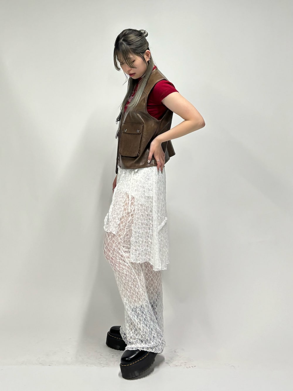 ホワイト系のその他パンツ、レッド系のニット/セーター、ブラウン系のベストを着用したレディースの春コーディネートの4枚目の写真