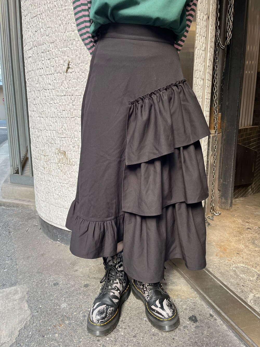 グリーン系のTシャツ/カットソー、ブラック系のスカート、シルバー系のネックレスを着用したレディースの秋コーディネートの8枚目の写真