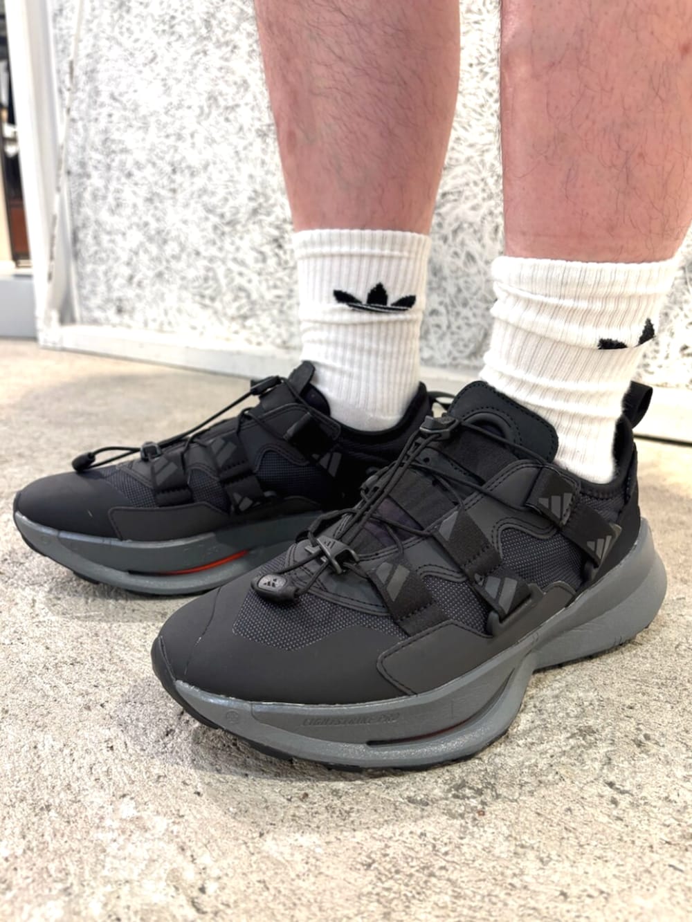 グリーン系のトップス、ブラック系のバックパック/リュック、ブラック系のパンツを着用したメンズの秋コーディネートの6枚目の写真