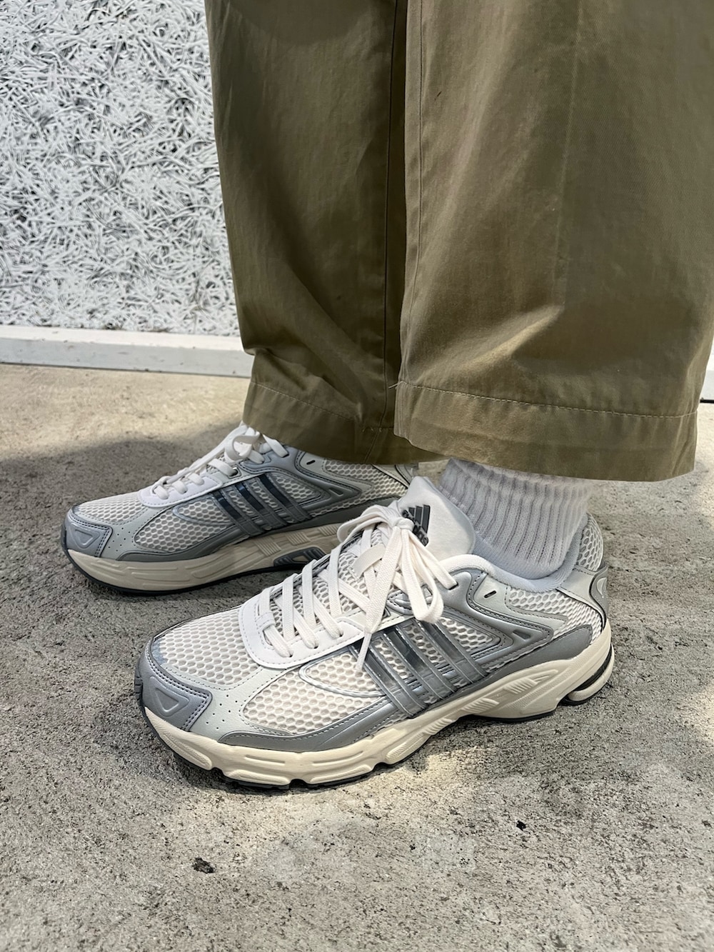 グリーン系のポロシャツ、グレー系のスニーカーを着用したメンズの冬コーディネートの3枚目の写真