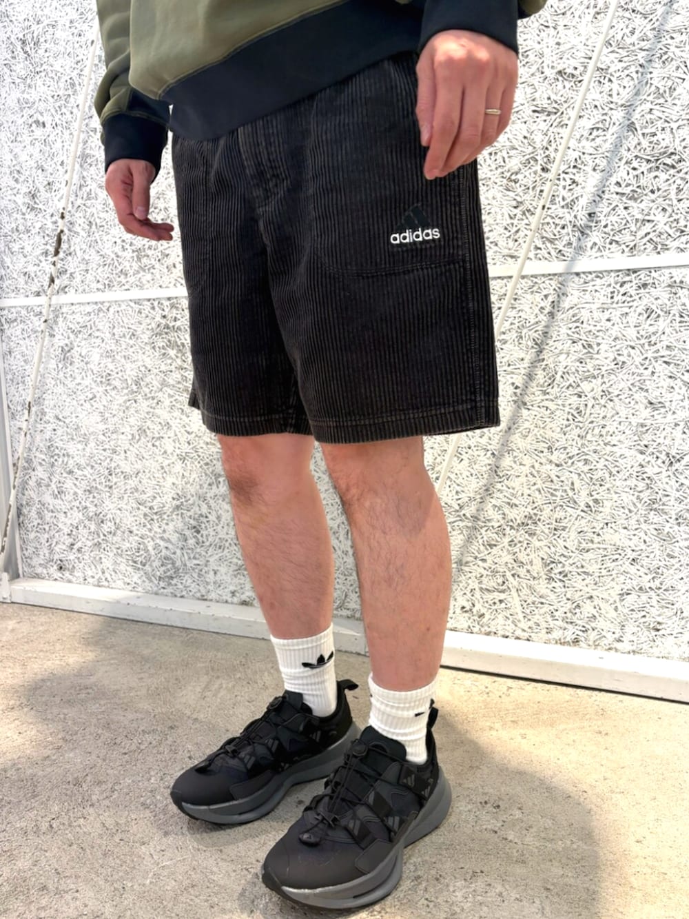 グリーン系のトップス、ブラック系のバックパック/リュック、ブラック系のパンツを着用したメンズの秋コーディネートの5枚目の写真