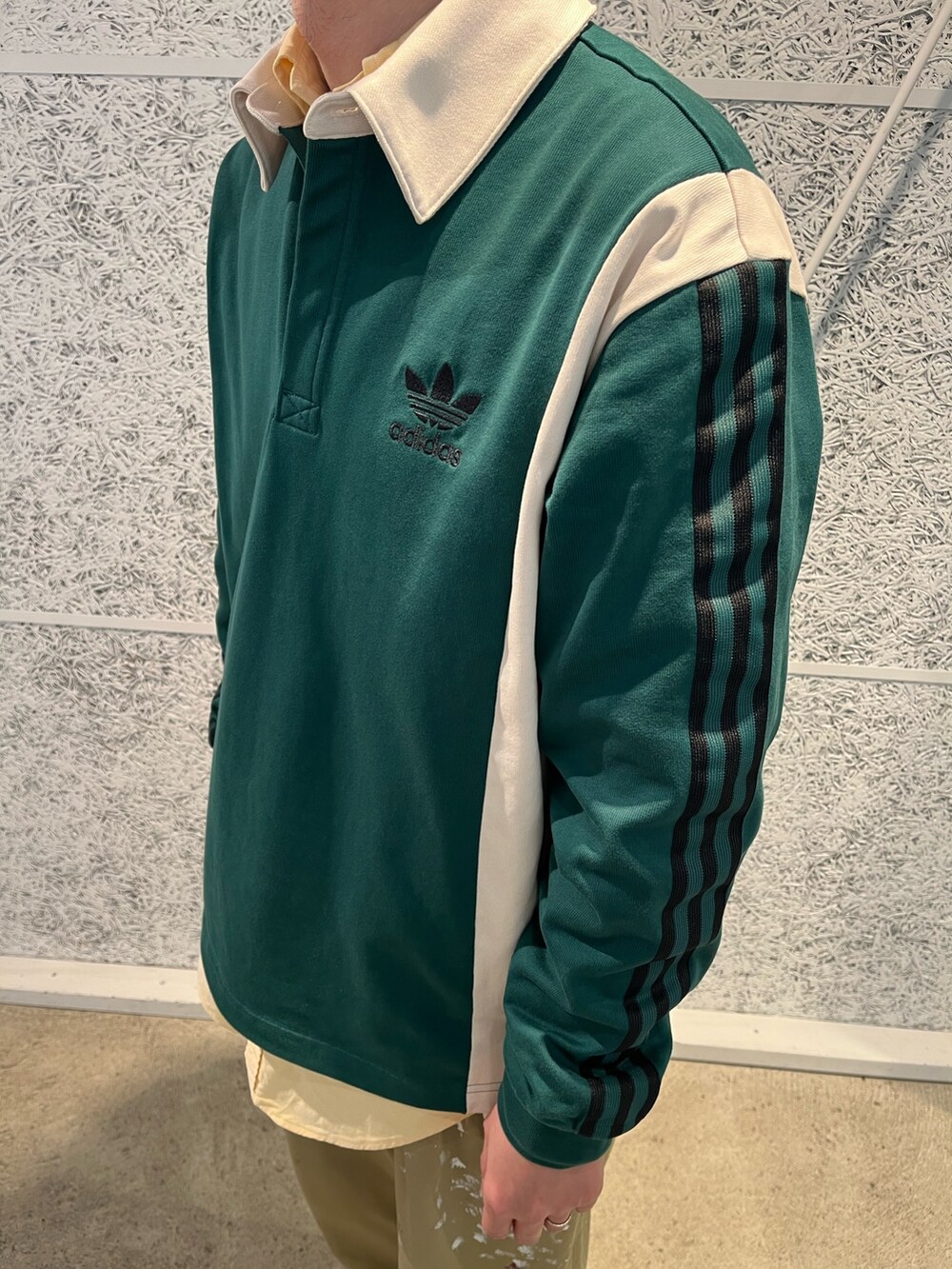 グリーン系のポロシャツ、グレー系のスニーカーを着用したメンズの冬コーディネートの2枚目の写真