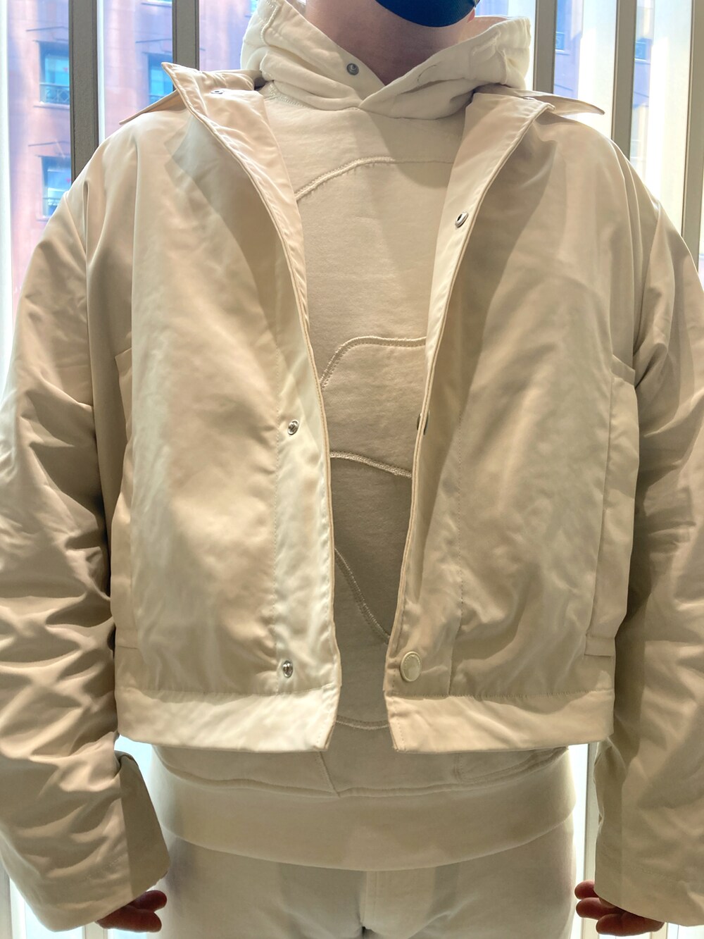 ベージュ系のスウェット、ベージュ系のステンカラーコート、ベージュ系のチノパンツを着用したメンズの春コーディネートの5枚目の写真