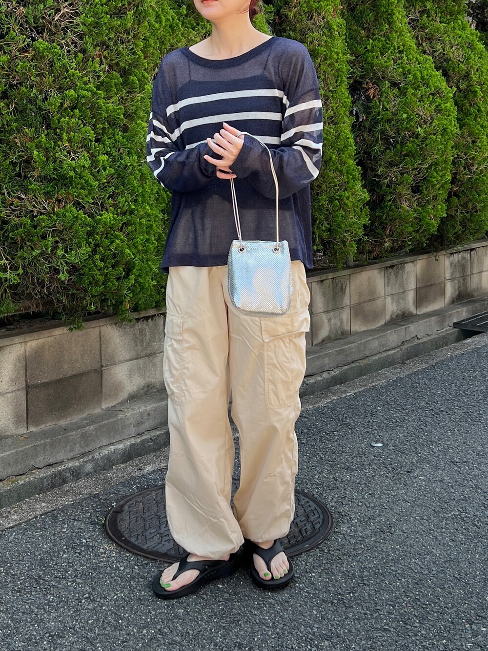 ホワイト系のパンツ、ブルー系のトップス、シルバー系のショルダーバッグを着用したレディースの夏コーディネートの3枚目の写真