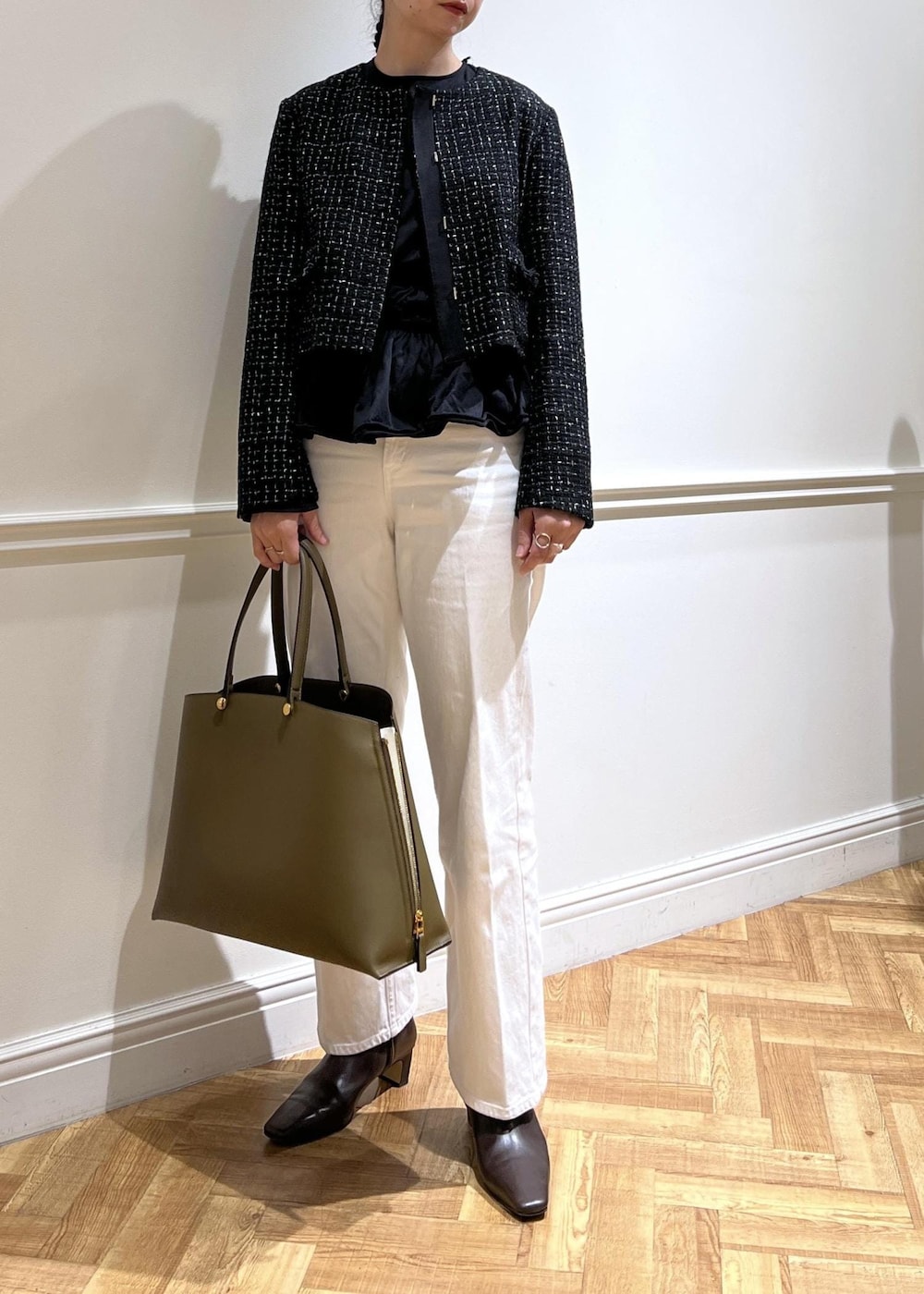 ホワイト系のデニムパンツ、ブラック系のTシャツ/カットソー、グリーン系のトートバッグを着用したレディースの秋コーディネートの2枚目の写真