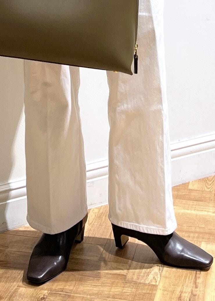 ホワイト系のデニムパンツ、ブラック系のTシャツ/カットソー、グリーン系のトートバッグを着用したレディースの秋コーディネートの7枚目の写真