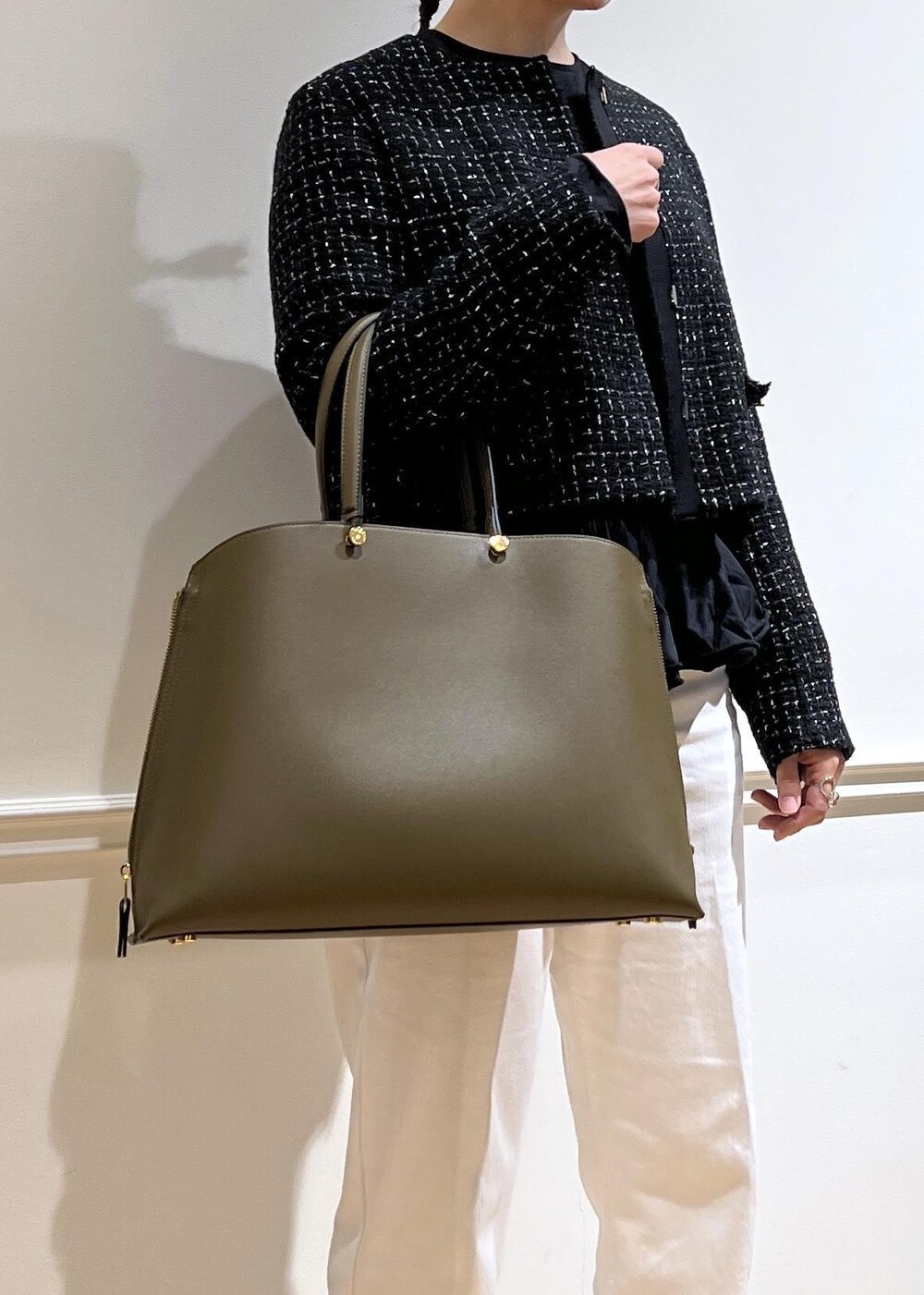 ホワイト系のデニムパンツ、ブラック系のTシャツ/カットソー、グリーン系のトートバッグを着用したレディースの秋コーディネートの8枚目の写真