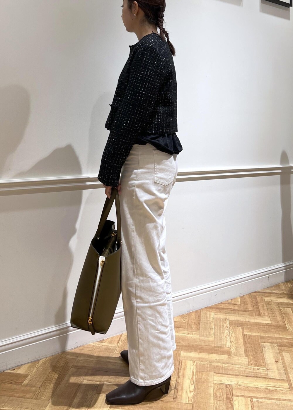 ホワイト系のデニムパンツ、ブラック系のTシャツ/カットソー、グリーン系のトートバッグを着用したレディースの秋コーディネートの4枚目の写真