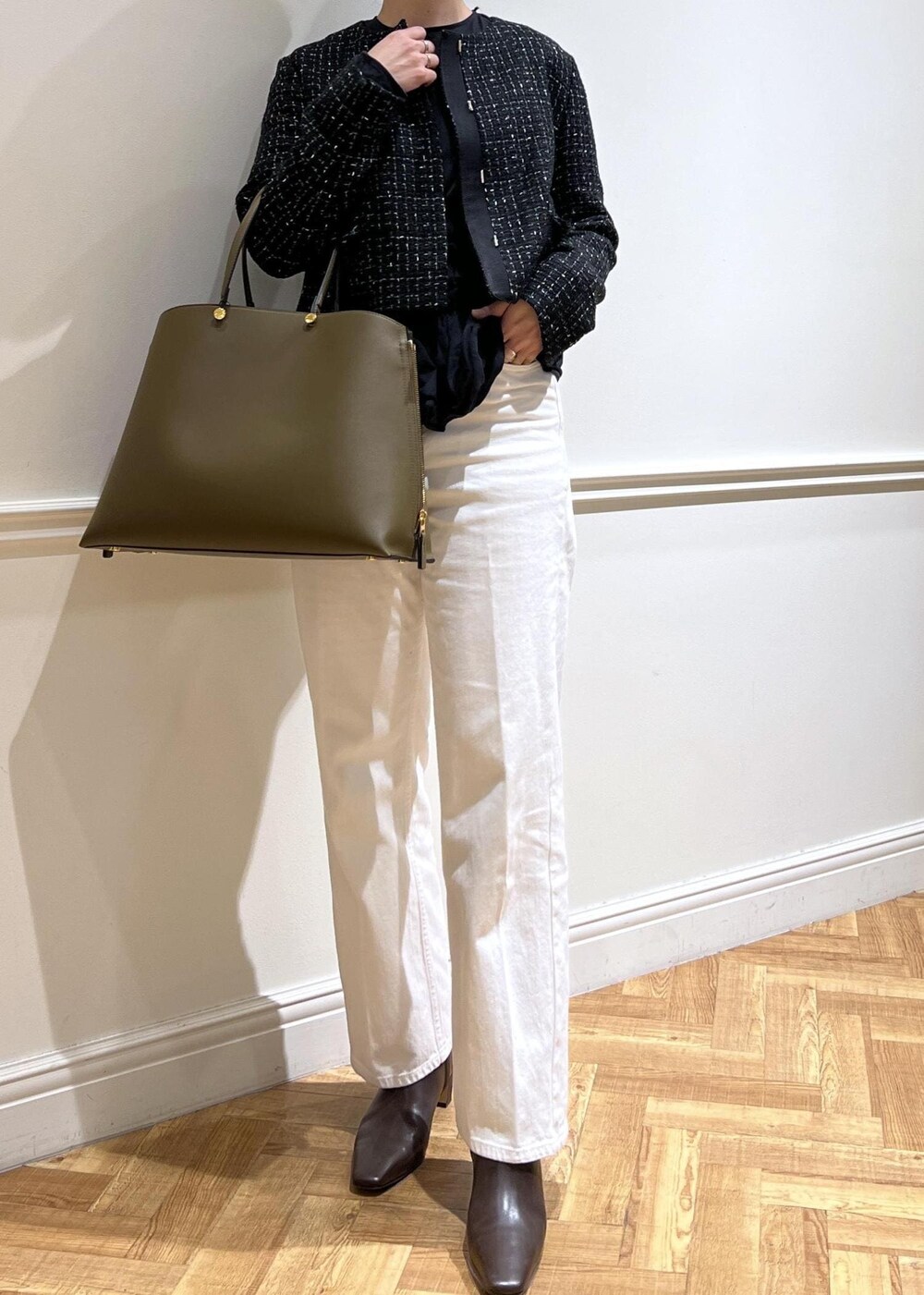 ホワイト系のデニムパンツ、ブラック系のTシャツ/カットソー、グリーン系のトートバッグを着用したレディースの秋コーディネートの3枚目の写真