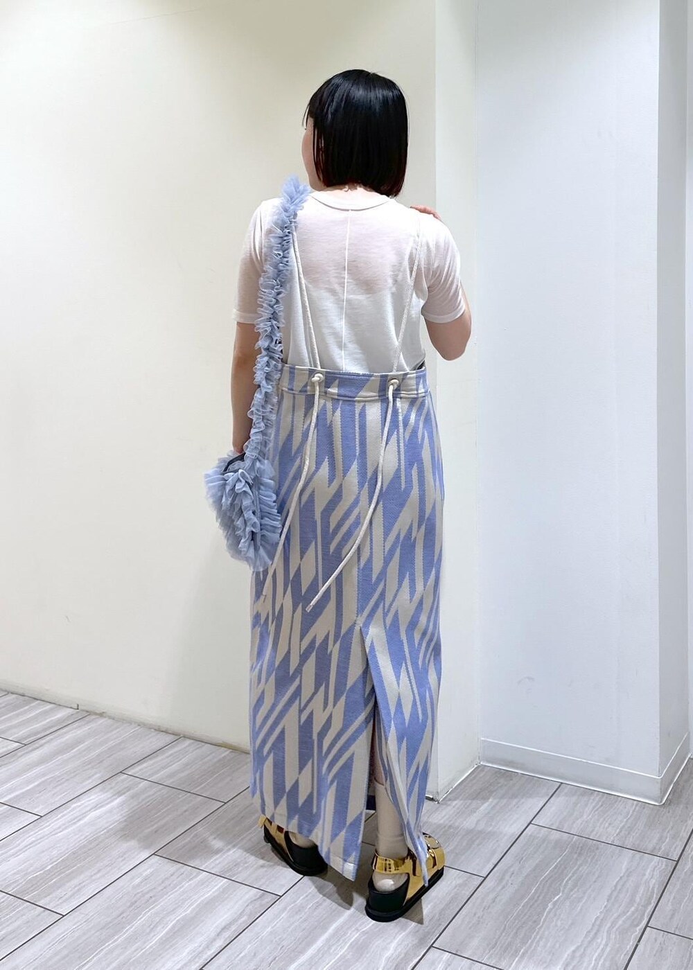 ゴールド系のサンダル、ホワイト系のTシャツ/カットソー、ブルー系のショルダーバッグを着用したレディースの春コーディネートの4枚目の写真