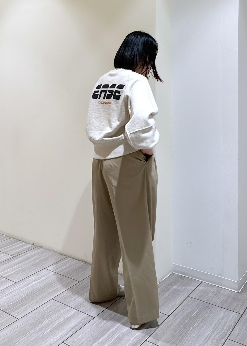 ブラック系のショルダーバッグ、シルバー系のバレエシューズ、ベージュ系のスラックスを着用したレディースの秋コーディネートの4枚目の写真