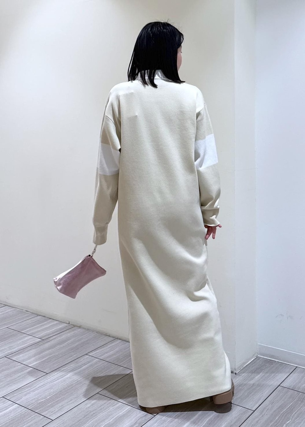 ベージュ系のブーツ、ホワイト系のブルゾン、ホワイト系のワンピースを着用したレディースの冬コーディネートの4枚目の写真