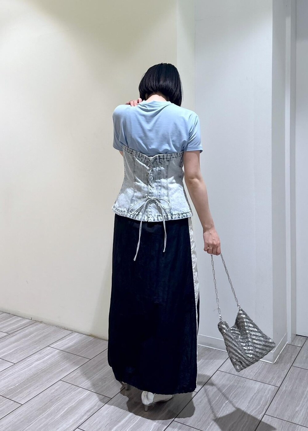 シルバー系のハンドバッグ、シルバー系のサンダル、ブラック系のスカートを着用したレディースの夏コーディネートの3枚目の写真