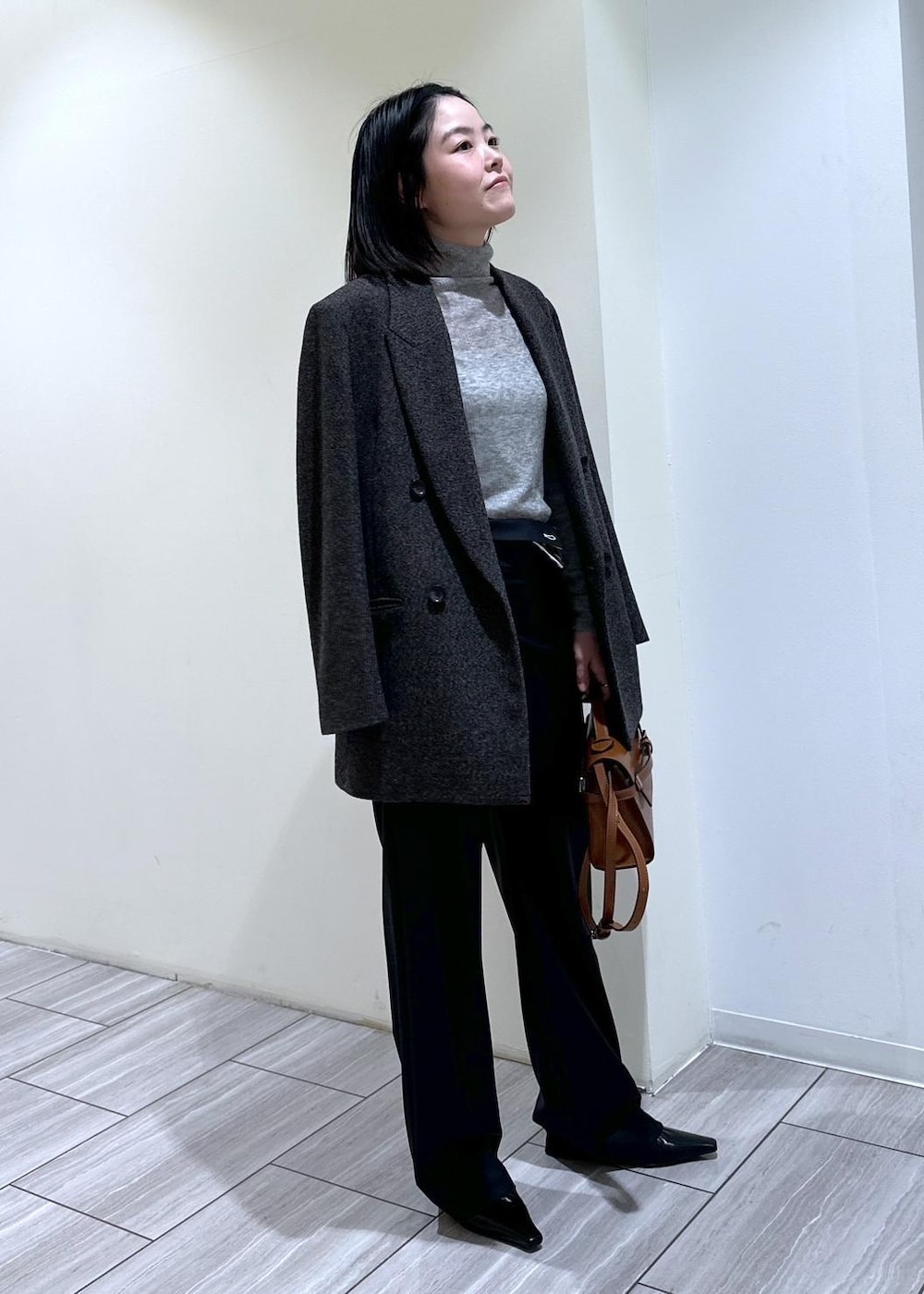 ブラック系のパンプス、グレー系のニット/セーター、ブラック系のスラックスを着用したレディースの秋コーディネートの3枚目の写真