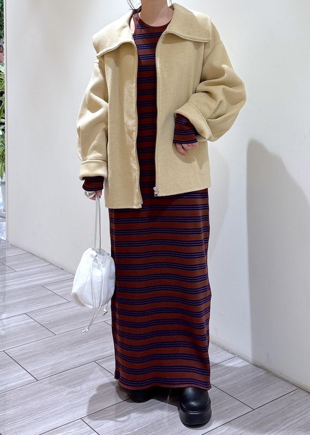 ブラック系のサンダル、ホワイト系のハンドバッグ、ブラウン系のワンピースを着用したレディースの秋コーディネートの5枚目の写真