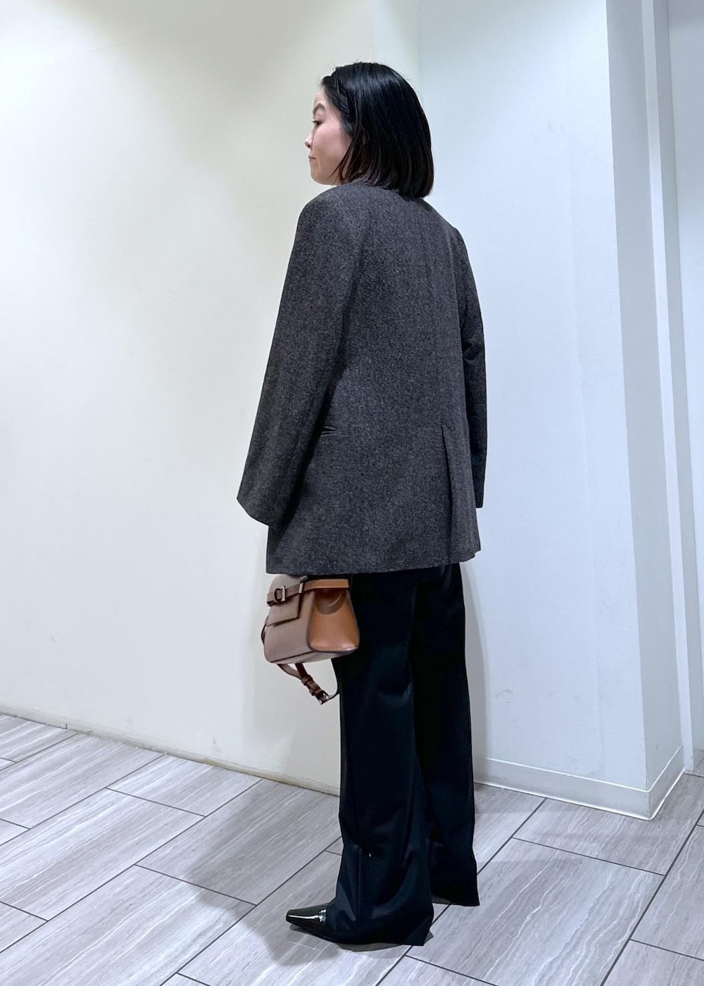 ブラック系のパンプス、グレー系のニット/セーター、ブラック系のスラックスを着用したレディースの秋コーディネートの2枚目の写真