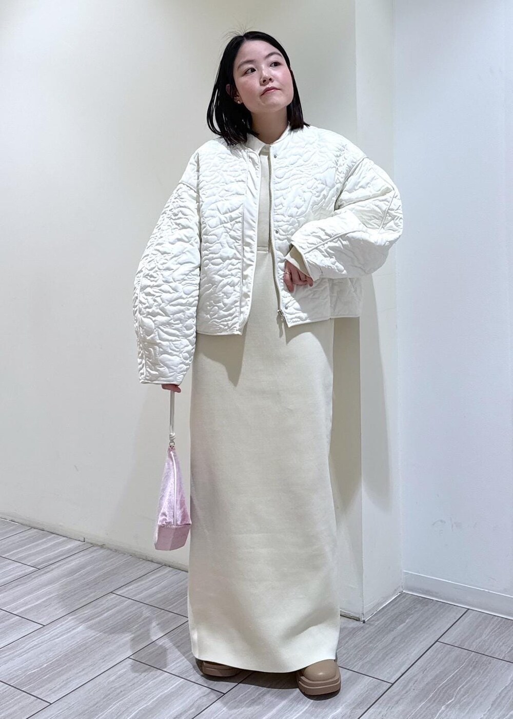 ベージュ系のブーツ、ホワイト系のブルゾン、ホワイト系のワンピースを着用したレディースの冬コーディネートの6枚目の写真