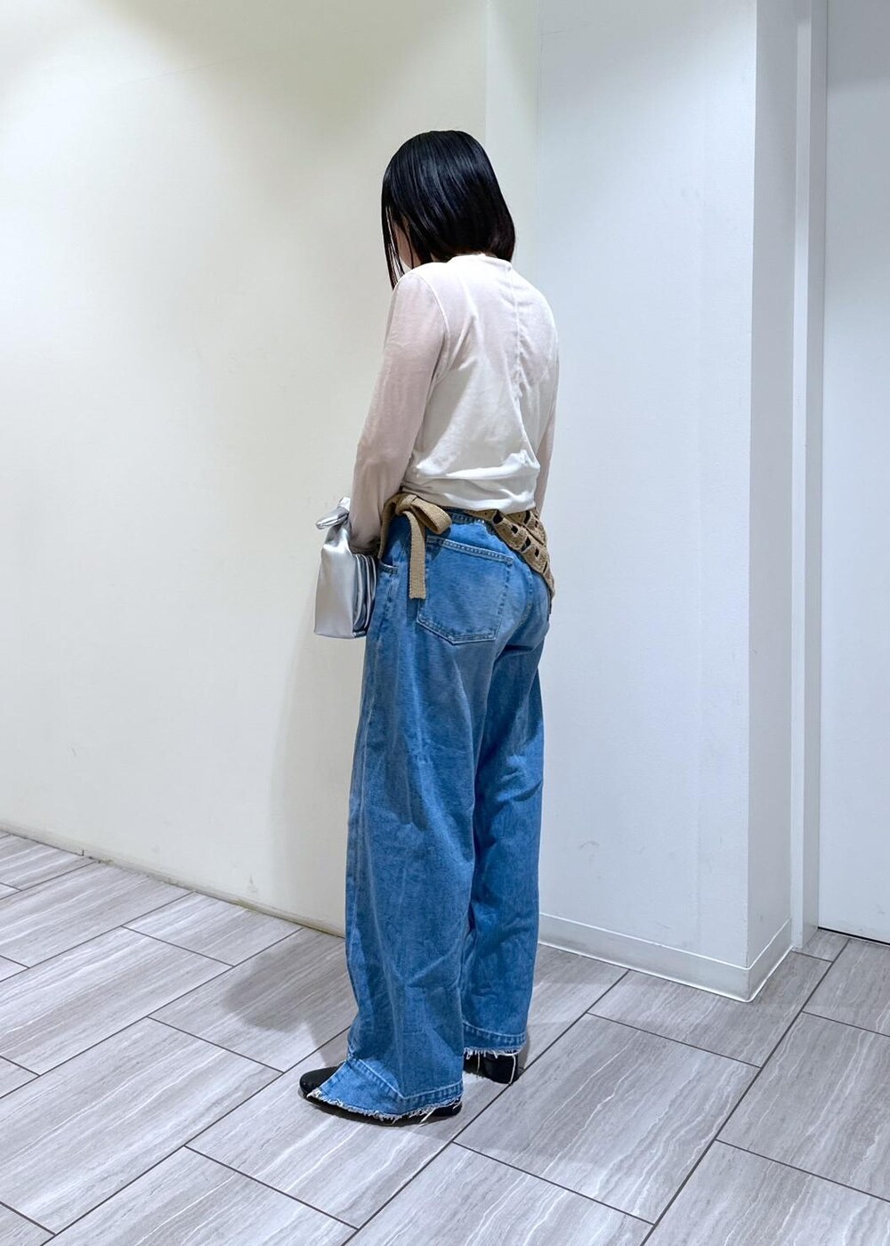 ブルー系のデニムパンツ、シルバー系のショルダーバッグ、ブラック系のパンプスを着用したレディースの秋コーディネートの2枚目の写真