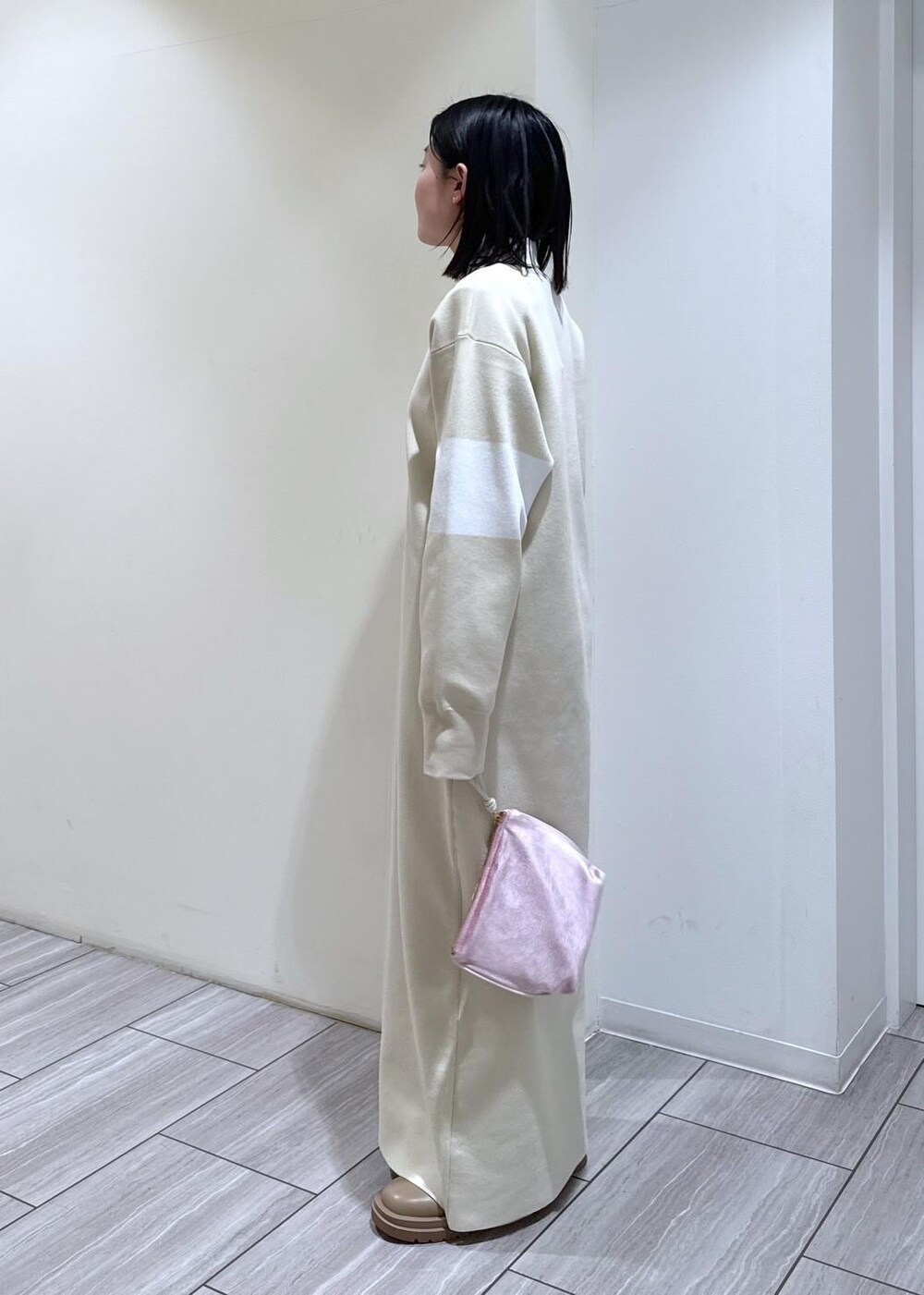 ベージュ系のブーツ、ホワイト系のブルゾン、ホワイト系のワンピースを着用したレディースの冬コーディネートの5枚目の写真