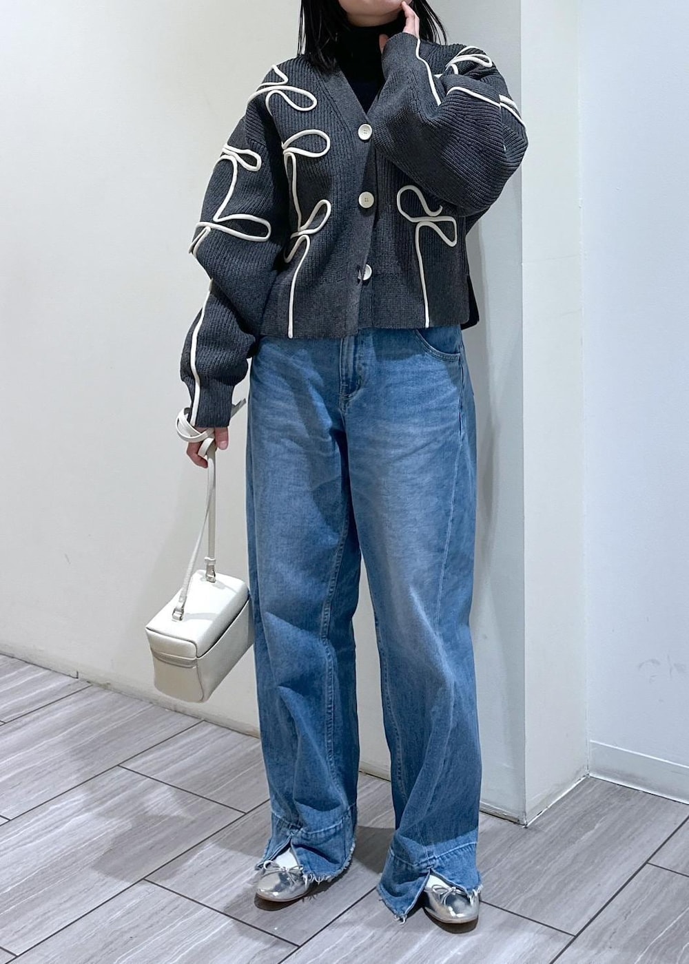グレー系のカーディガン/ボレロ、ホワイト系のショルダーバッグ、シルバー系のバレエシューズを着用したレディースの冬コーディネートの6枚目の写真