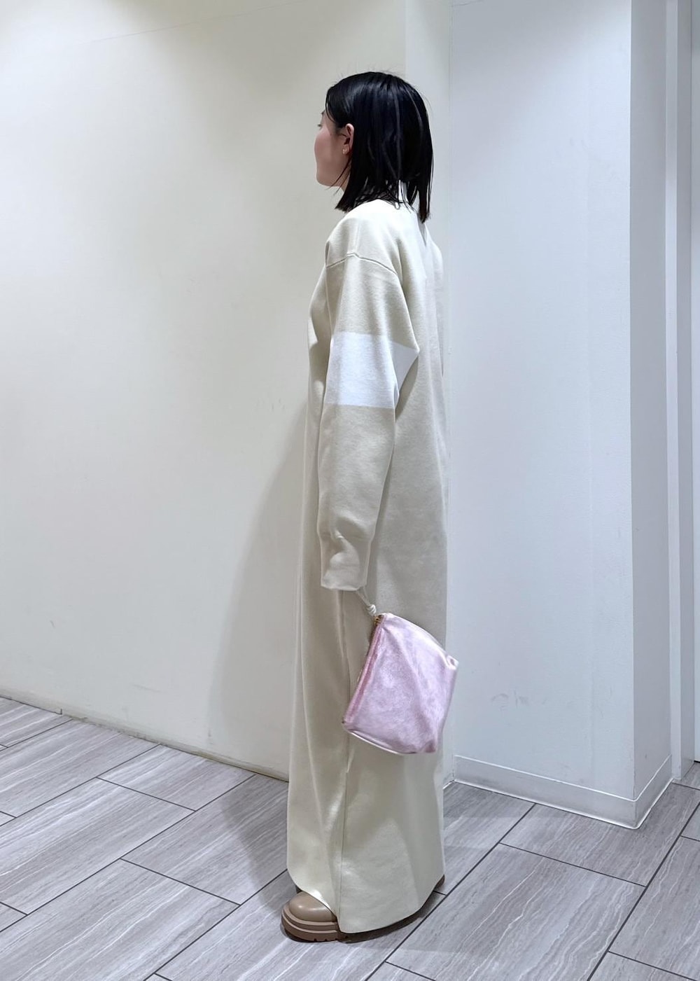 ベージュ系のブーツ、ホワイト系のブルゾン、ホワイト系のワンピースを着用したレディースの冬コーディネートの3枚目の写真