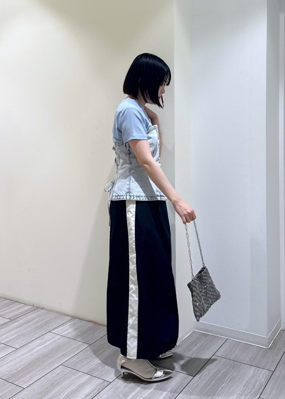 シルバー系のハンドバッグ、シルバー系のサンダル、ブラック系のスカートを着用したレディースの夏コーディネートの4枚目の写真