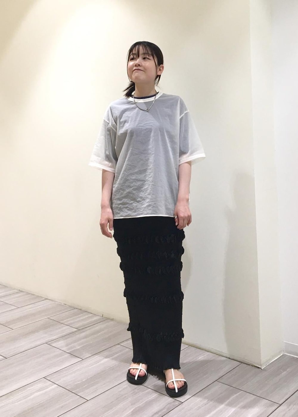 ブラック系のサンダル、ホワイト系のTシャツ/カットソー、ブラック系のスカートを着用したレディースの夏コーディネートの4枚目の写真