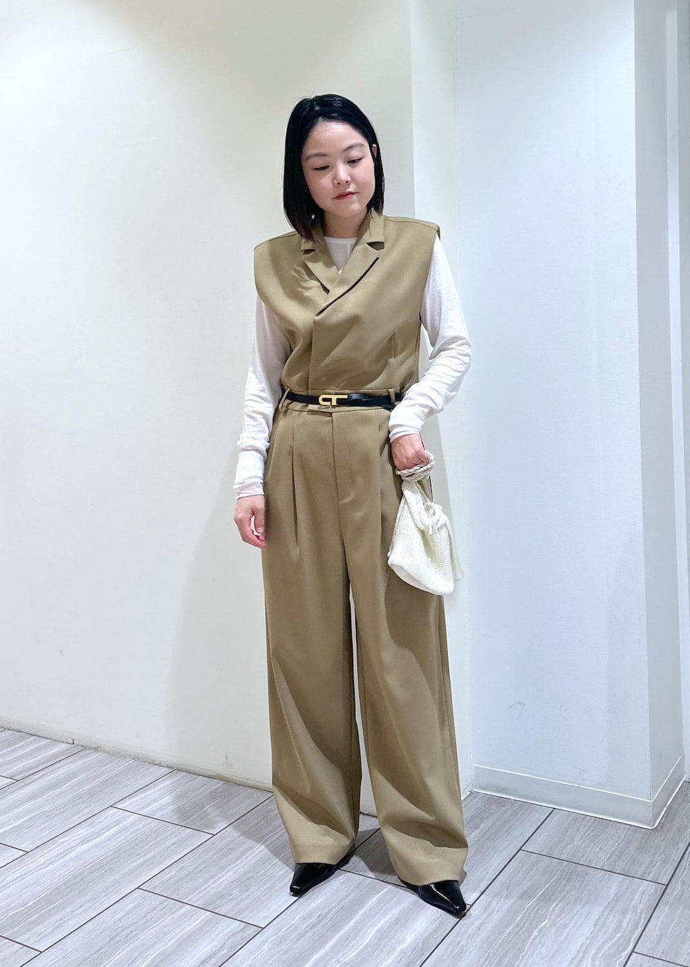 ホワイト系のショルダーバッグ、ベージュ系のサロペット/オーバーオール、ブラック系のパンプスを着用したレディースの秋コーディネートの4枚目の写真