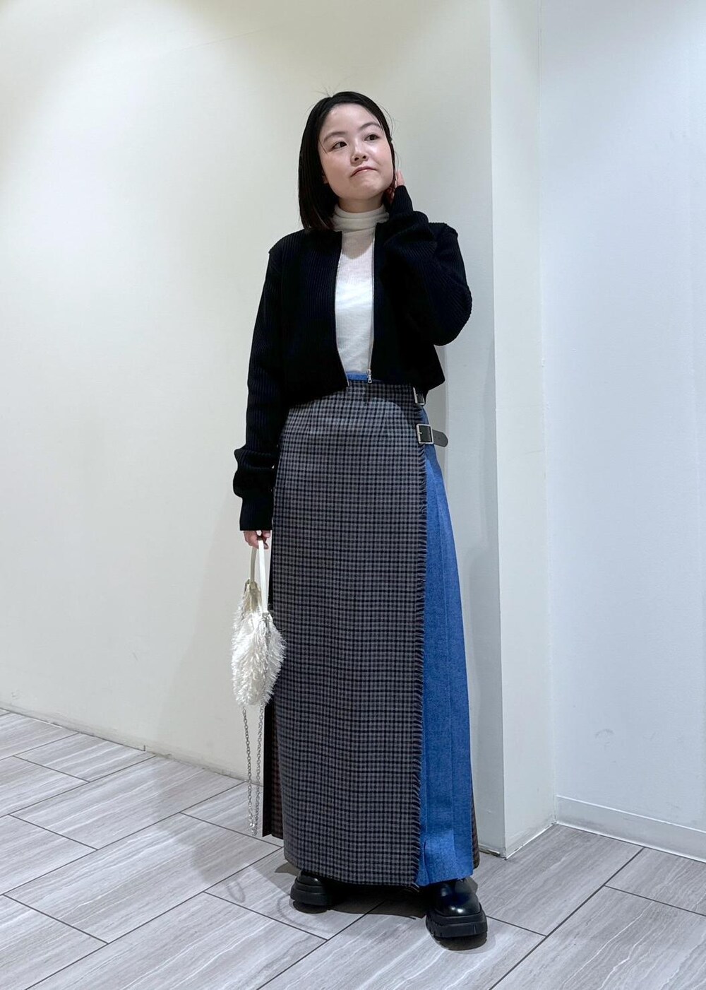 ブラック系のその他シューズ、グレー系のスカート、ホワイト系のニット/セーターを着用したレディースの秋コーディネートの2枚目の写真