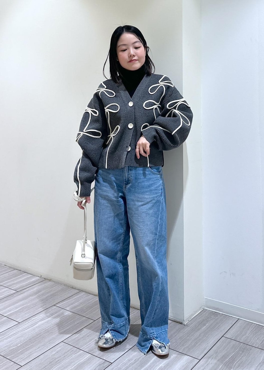 グレー系のカーディガン/ボレロ、ホワイト系のショルダーバッグ、シルバー系のバレエシューズを着用したレディースの冬コーディネートの7枚目の写真