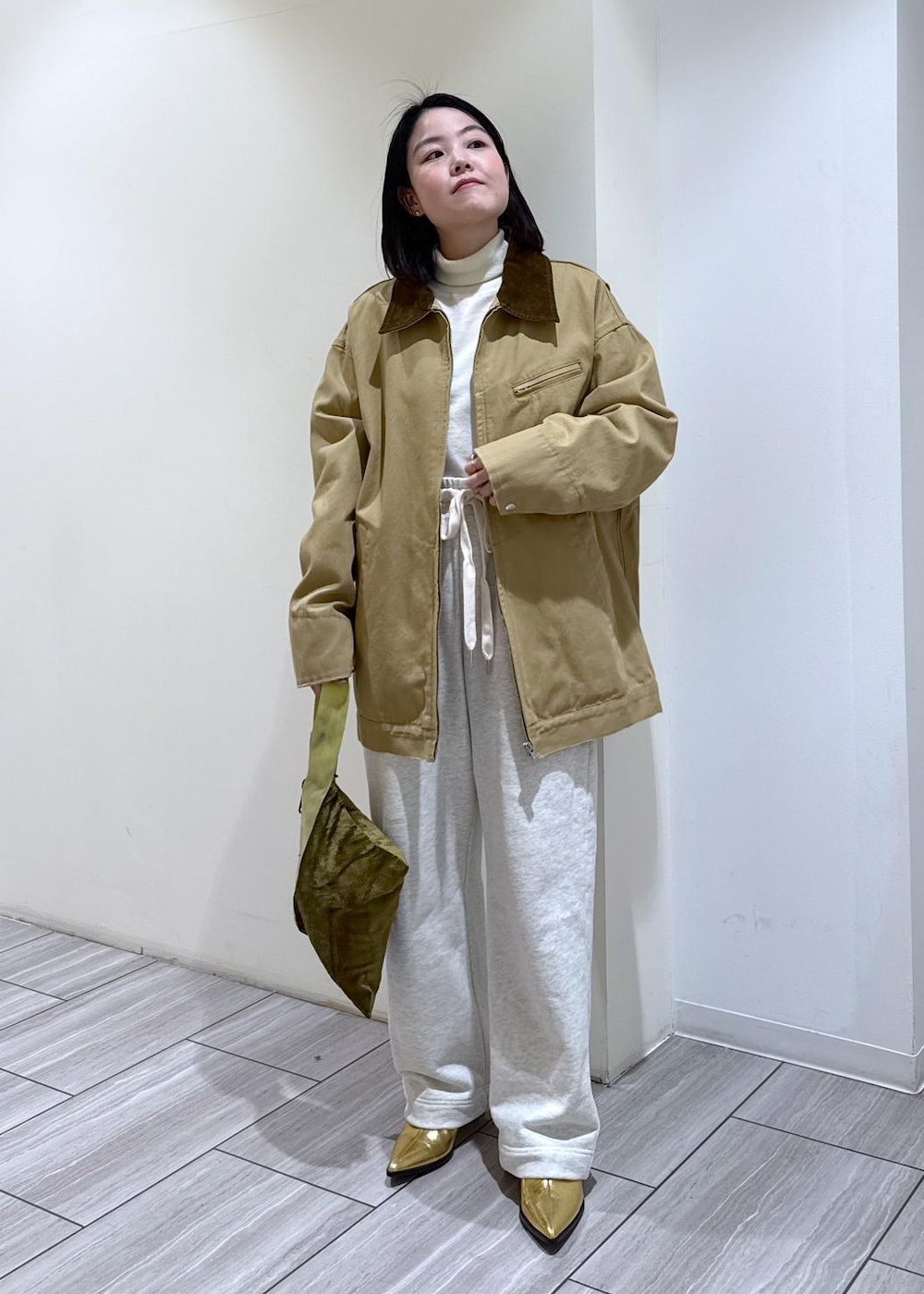 ゴールド系のブーツ、ホワイト系のスウェットパンツ、ベージュ系のその他アウターを着用したレディースの冬コーディネートの6枚目の写真