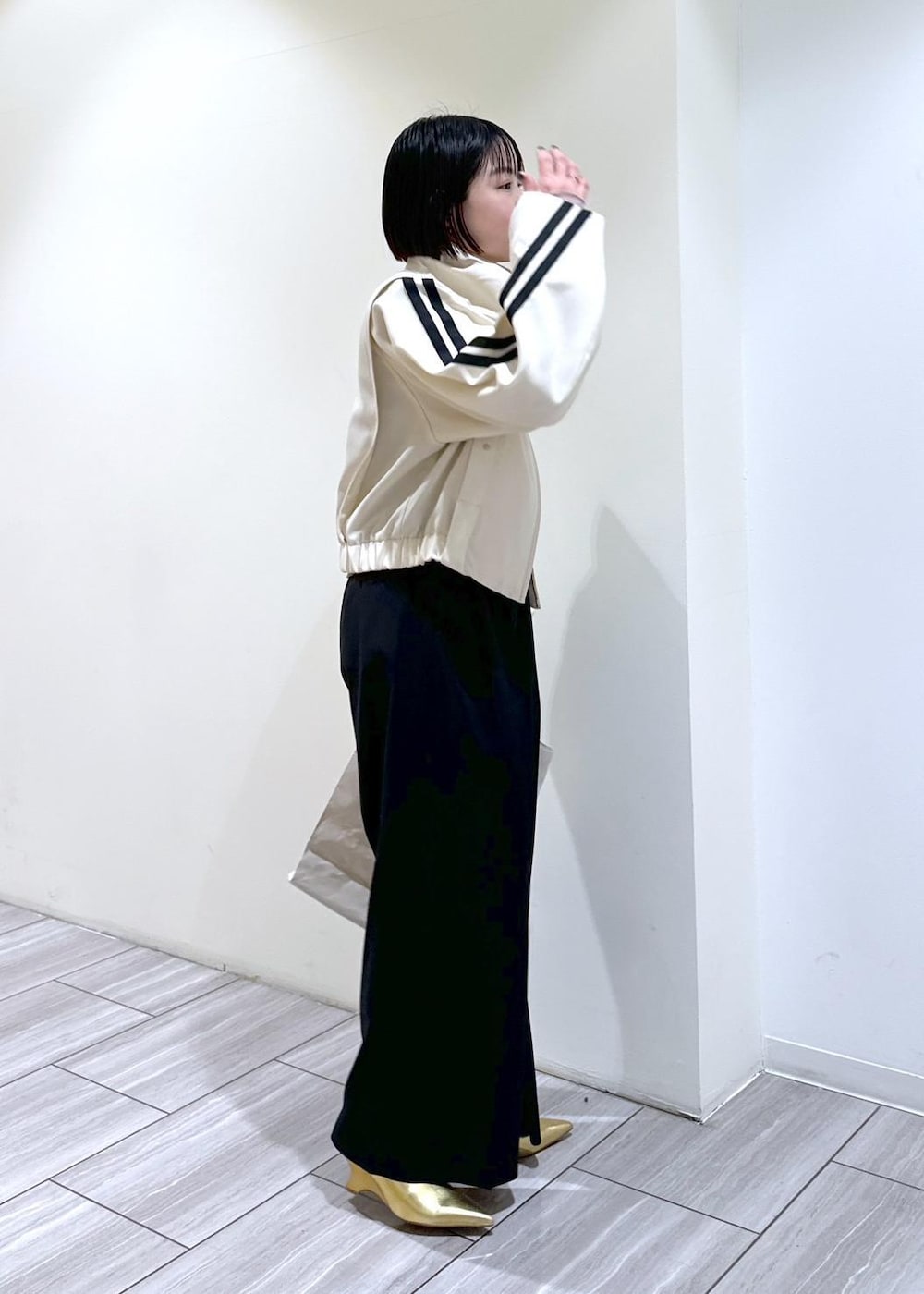 ゴールド系のその他シューズ、ホワイト系のブルゾン、グレー系のTシャツ/カットソーを着用したレディースの春コーディネートの4枚目の写真